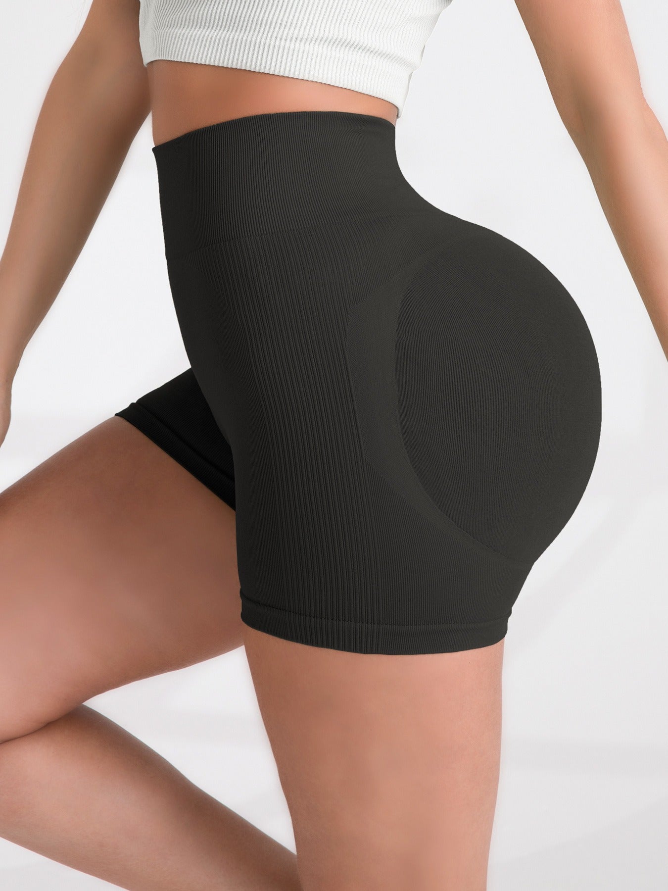 Black women's yoga shorts worn by a person on a white background