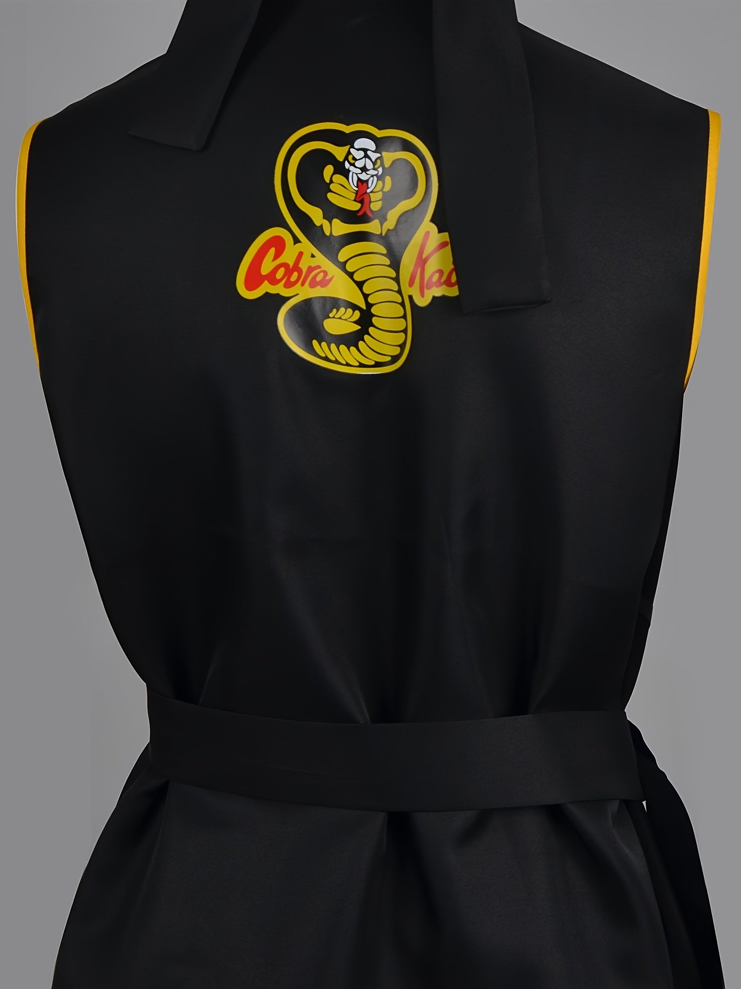 Black taekwondo uniform with Cobra Kai logo on a gray background