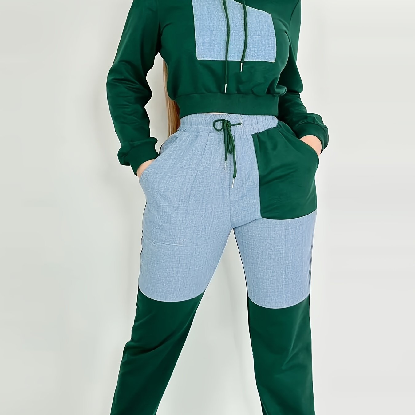 The backview of a green and light blue women's luxury tracksuit set on a white background