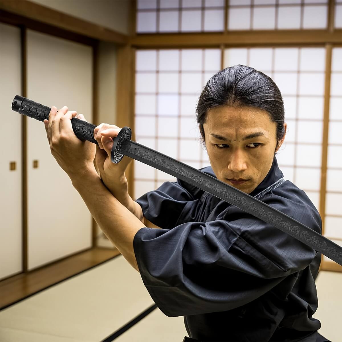 Person in traditional attire holding a training sword in a martial arts setting
