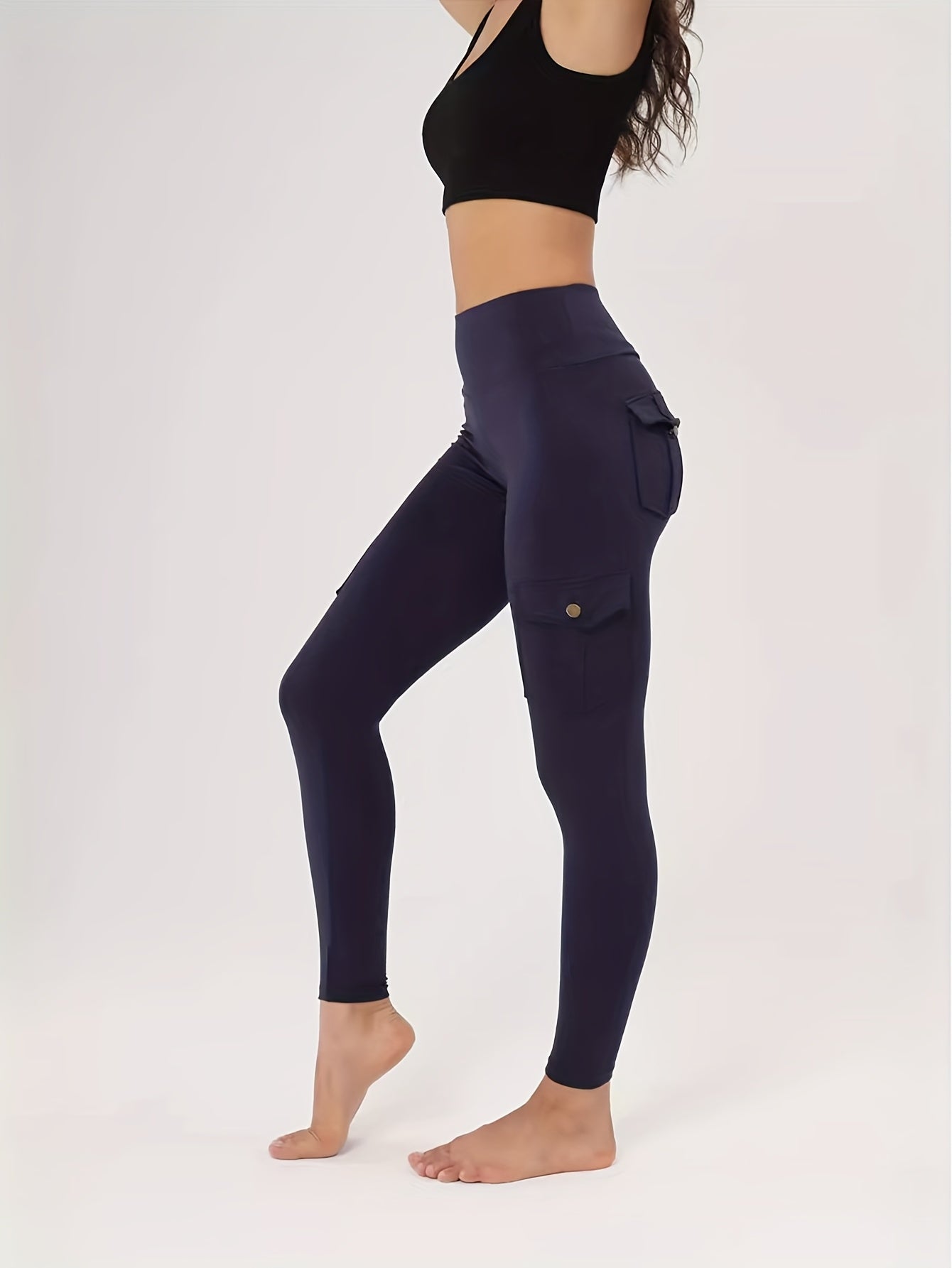 Person wearing navy yoga leggings with pockets on a white background