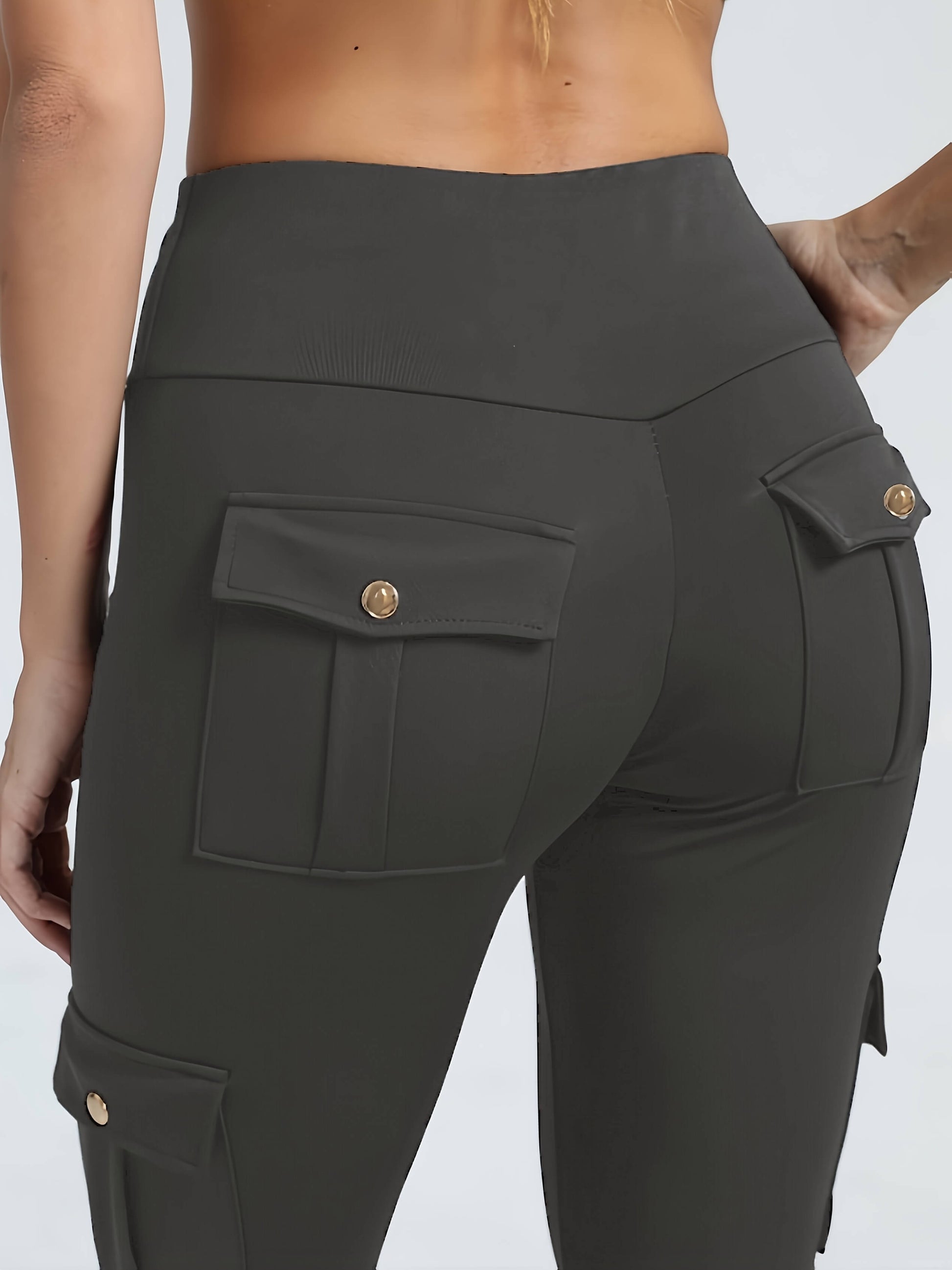 The back view of a woman wearing a pair of grey yoga legging sold by 100 Spartans