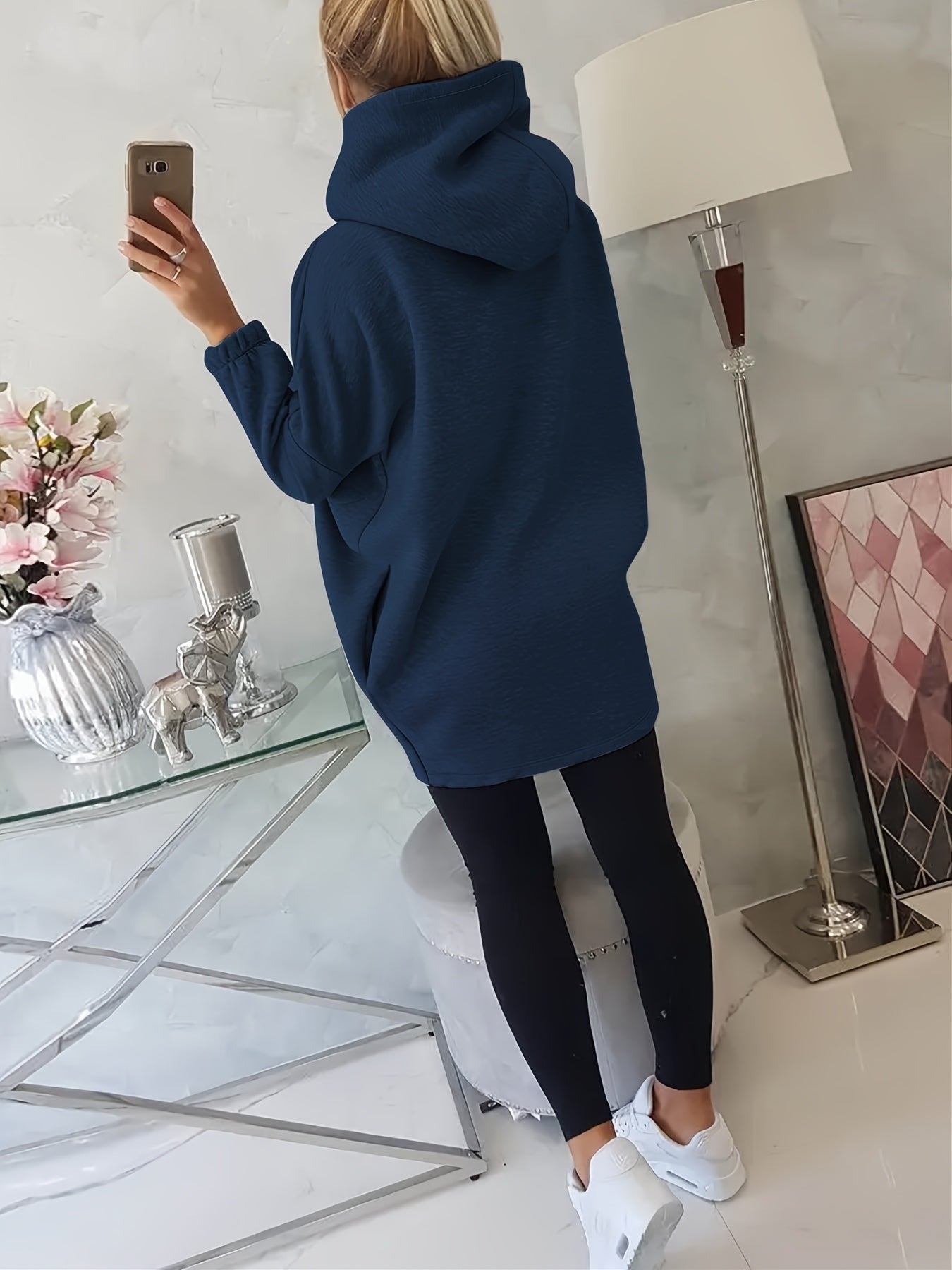 The back view of a person wearing a blue women’s oversized zip-up hoodie