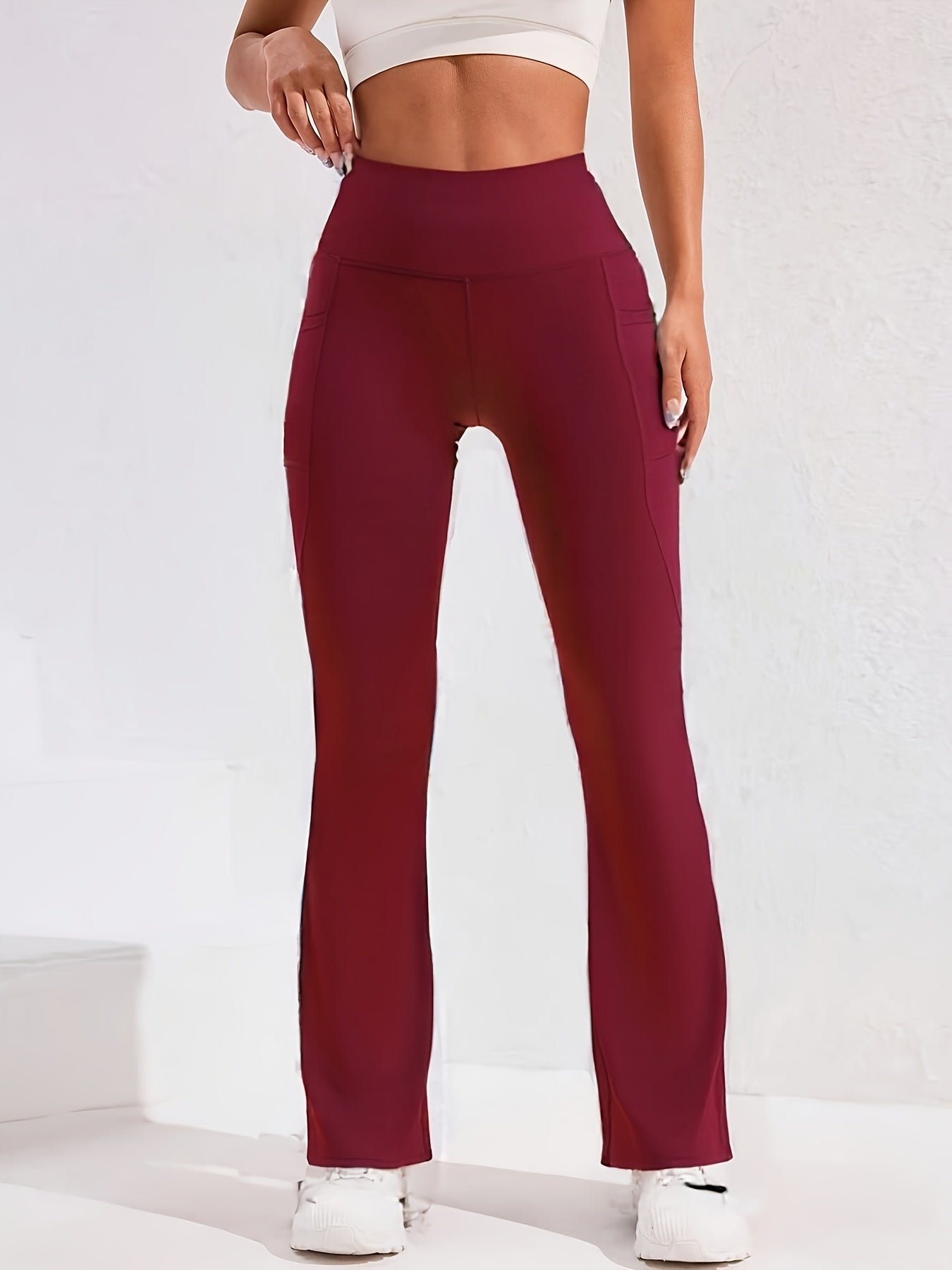 A woman wearing a red women’s flare leggings sold by 100 Spartans