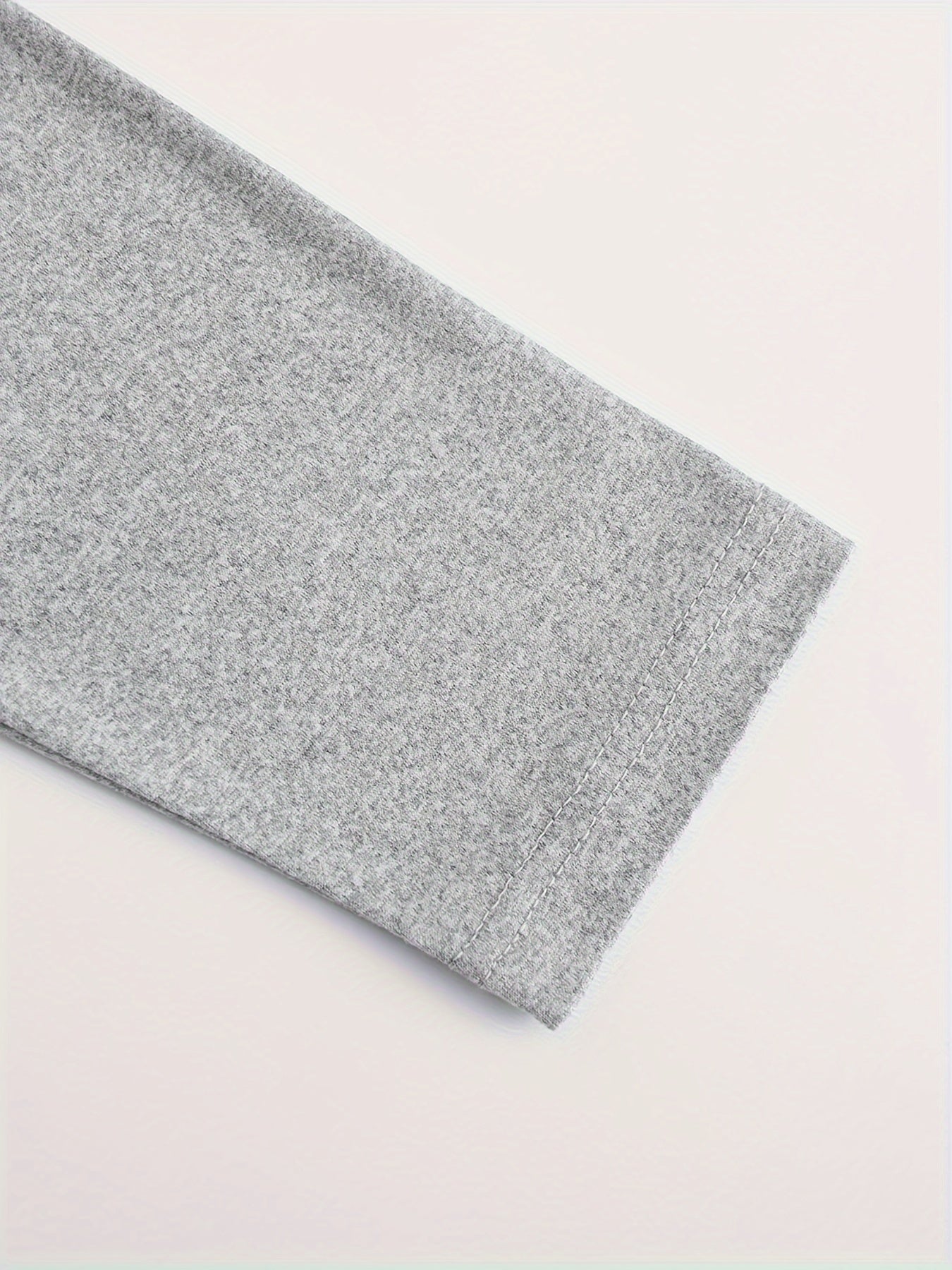 Gray textured fabric on a light pink background