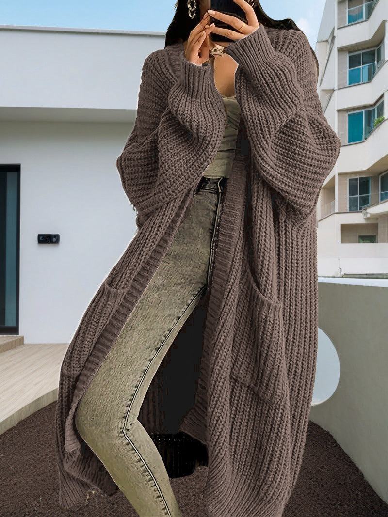 Person wearing a long brown cardigan in an urban setting