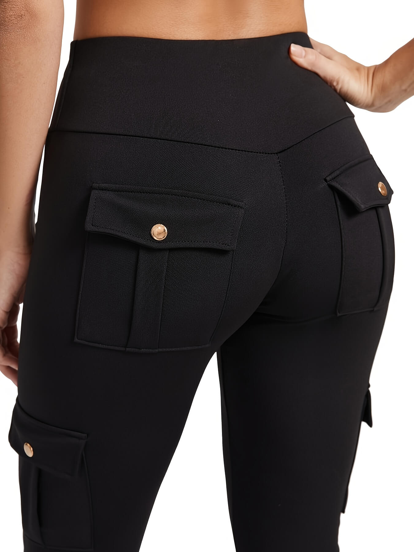 The back view of a woman wearing a pair of black yoga legging sold by 100 Spartans