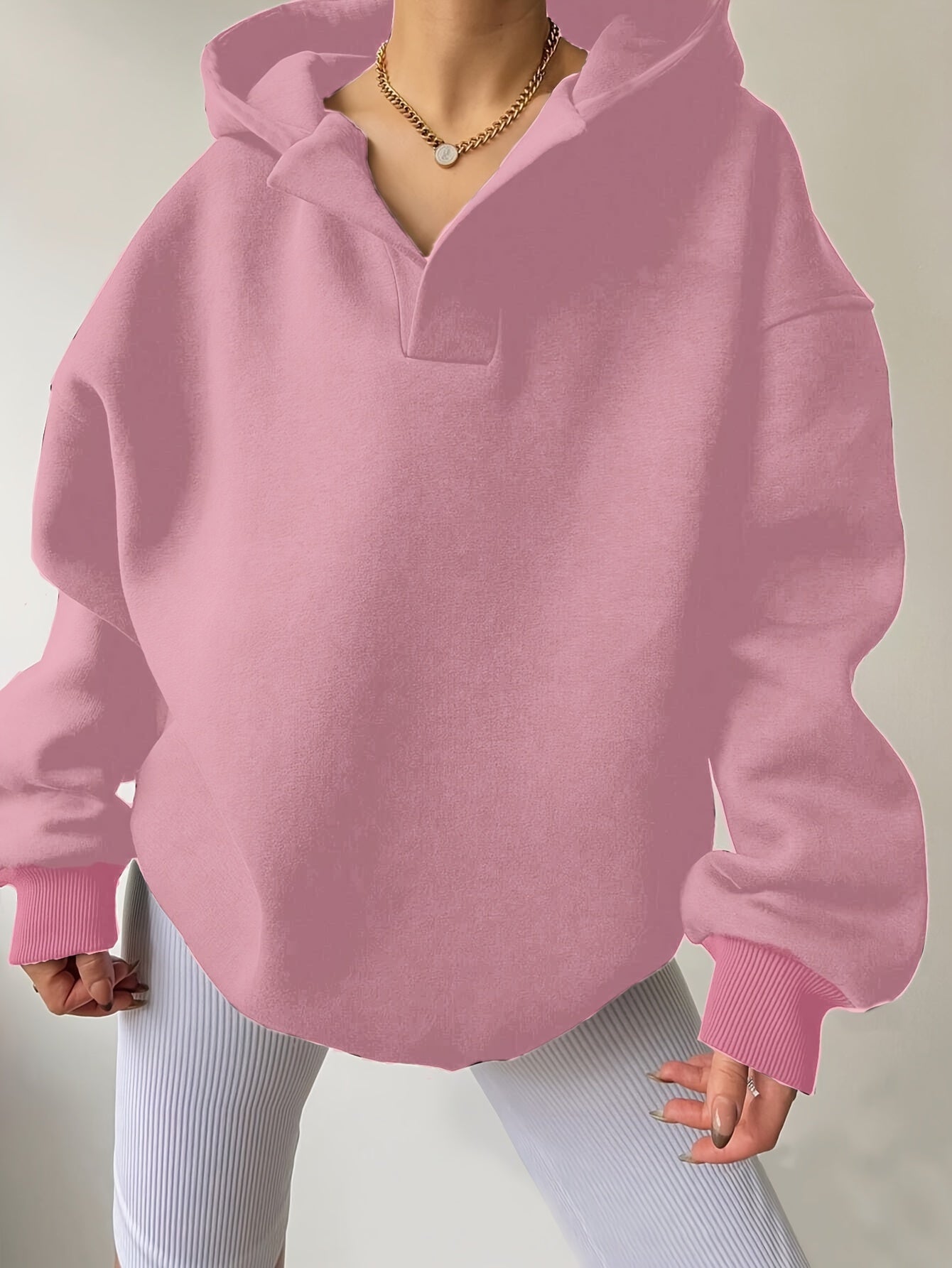 The front view of a woman wearing a pink winter hoodie for women sold by 100 Spartans