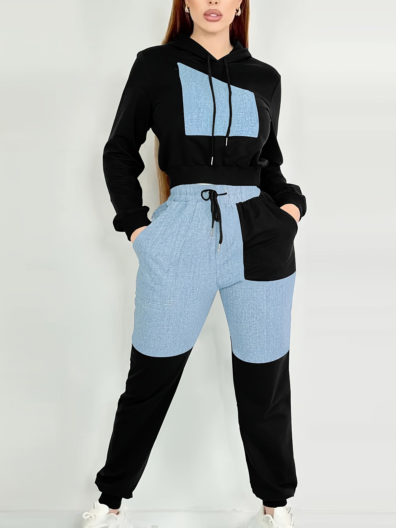 Person wearing a black and blue two-piece women's luxury tracksuit set on a white background