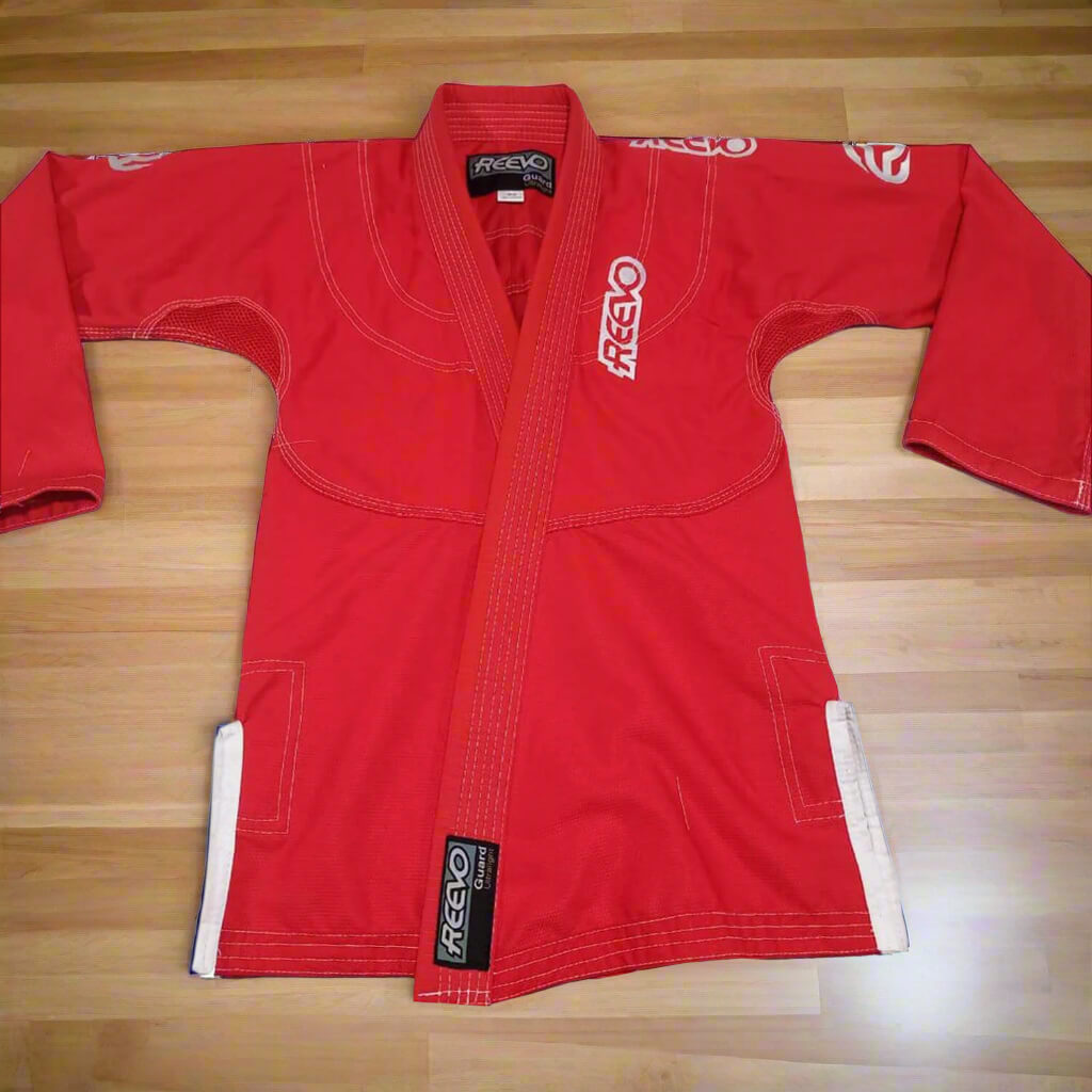 Red bjj gi with 'Freevo' branding on a wooden floor