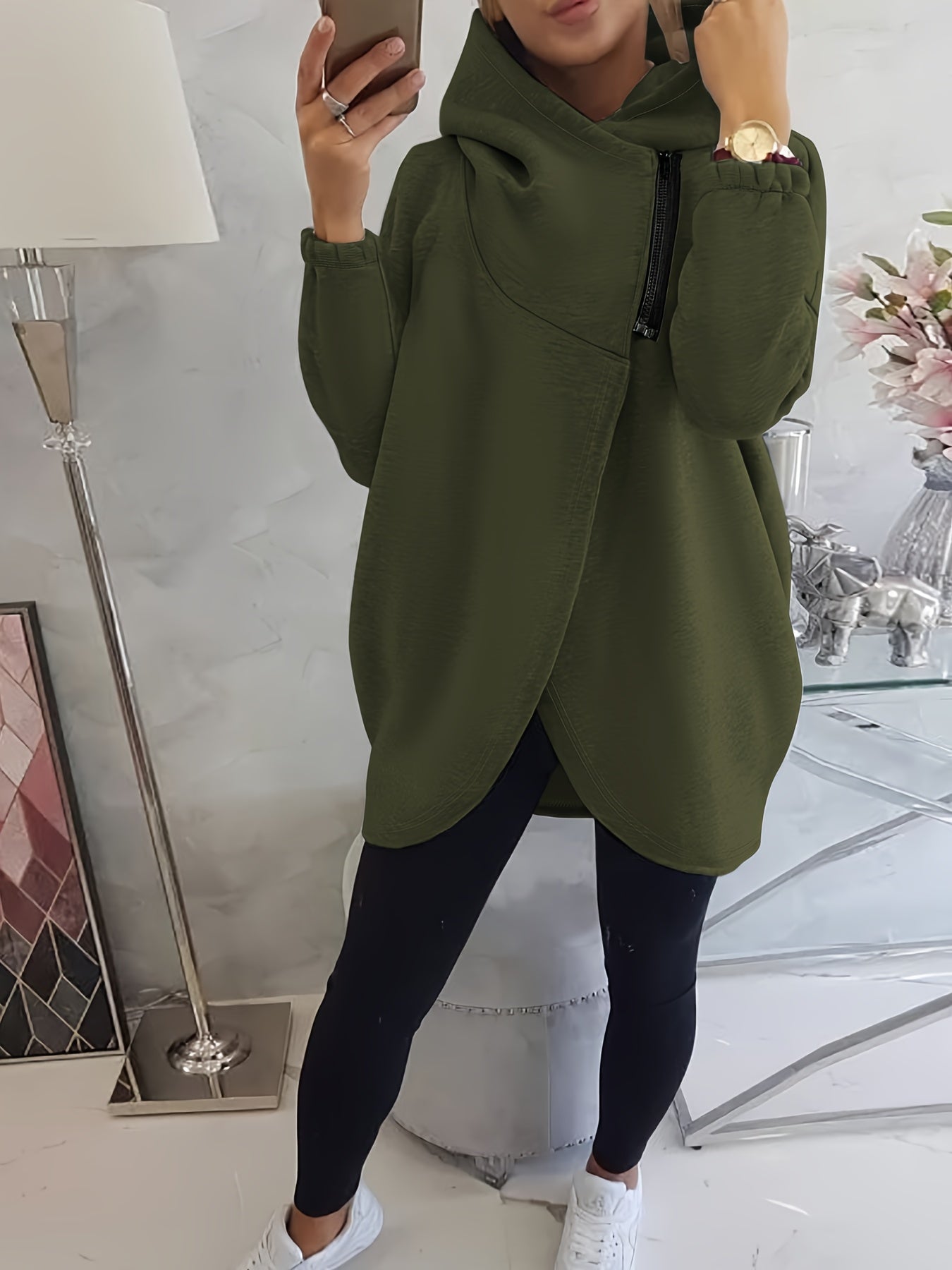 A person wearing a camouflage women’s oversized zip-up hoodie
