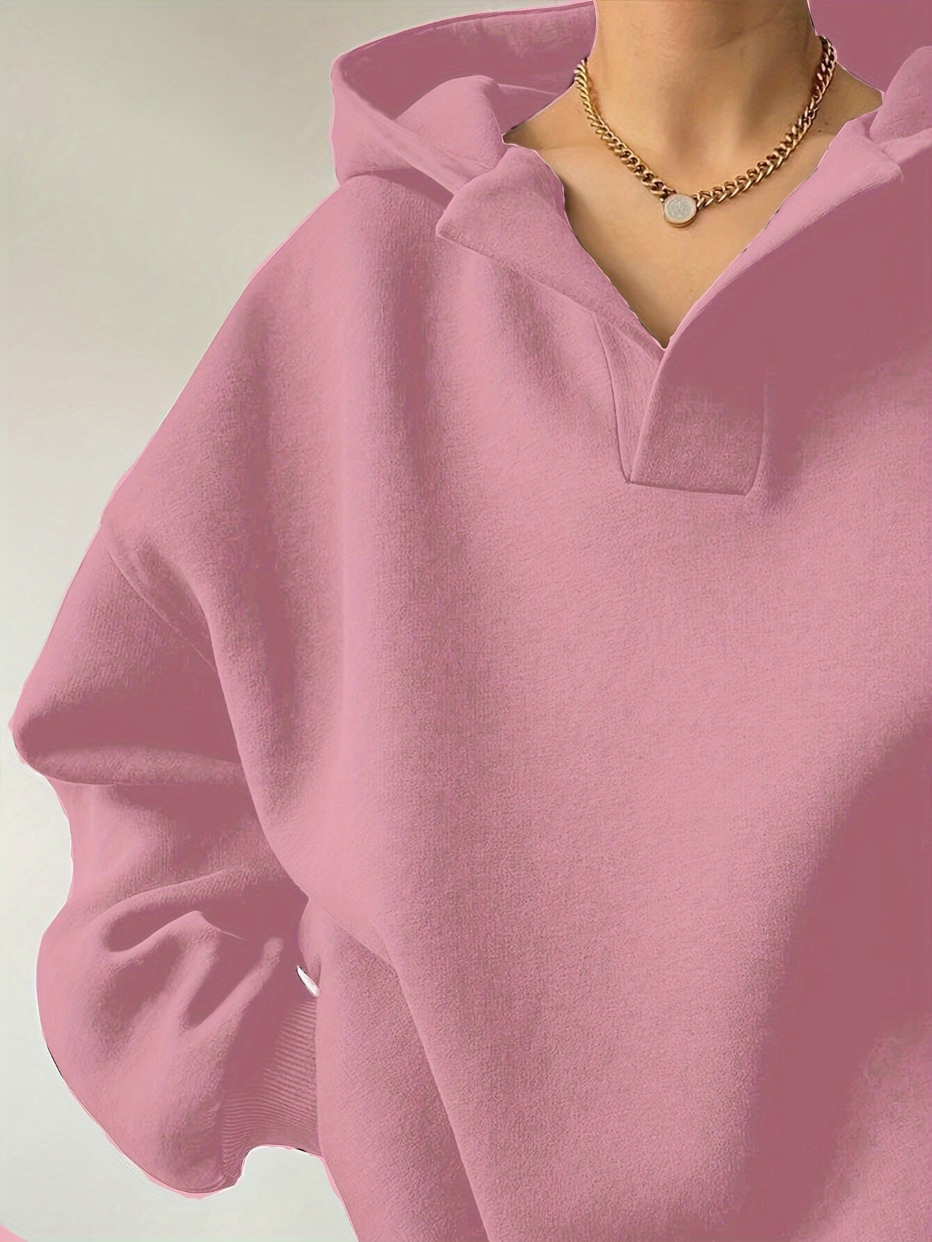 The front view of a woman wearing a pink winter hoodie for women sold by 100 Spartans