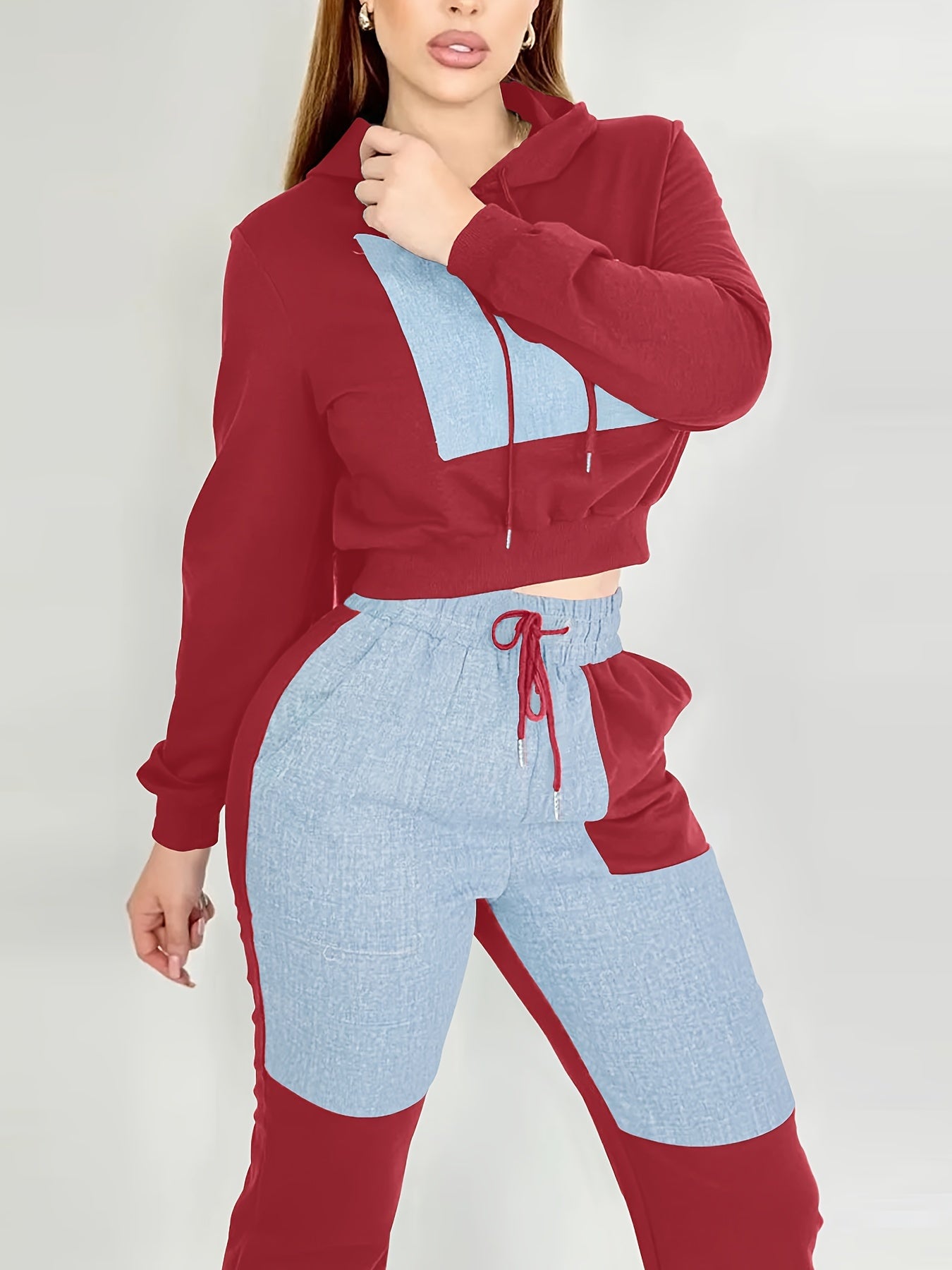 Person wearing a red and blue two-tone women's luxury tracksuit set on a white background