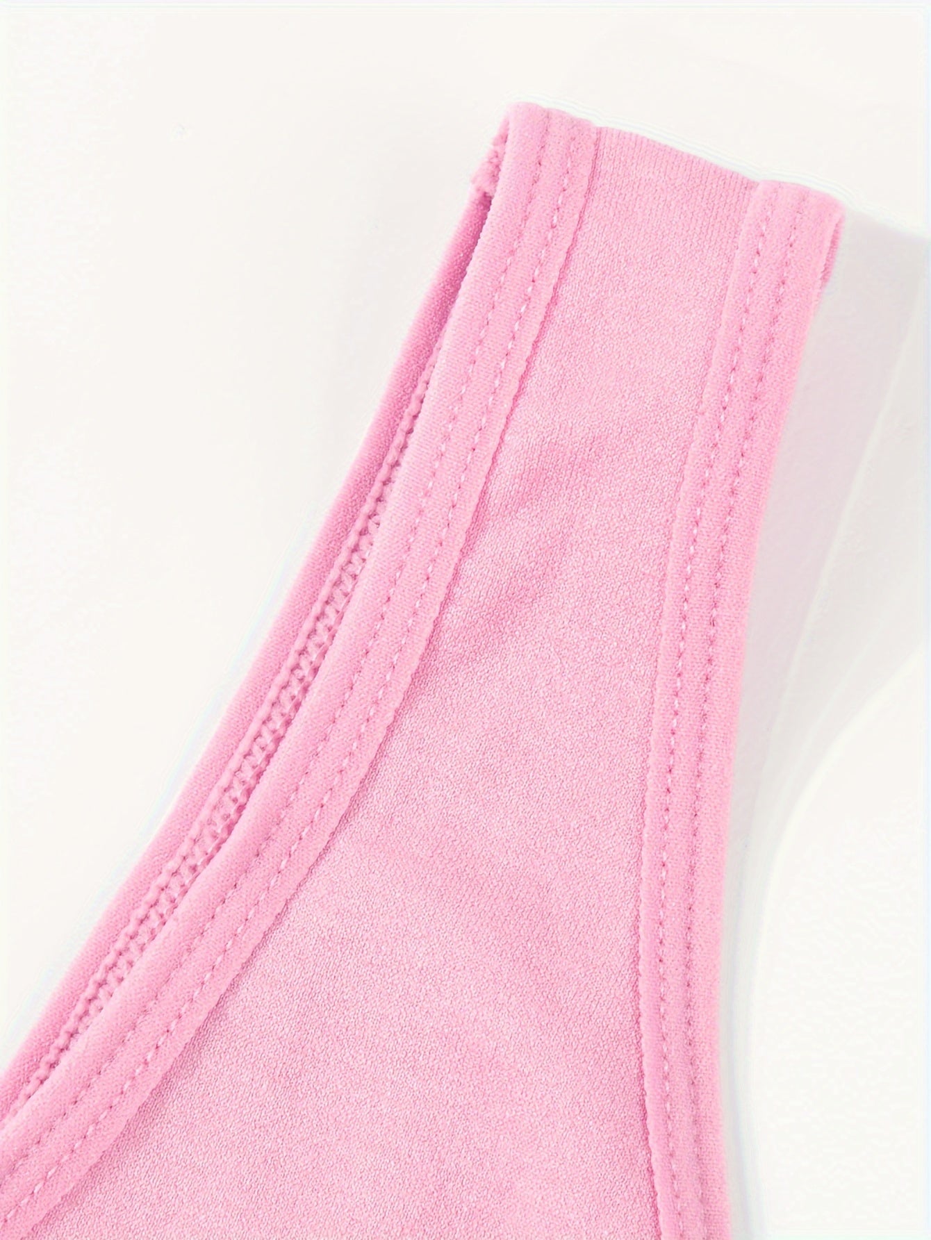 A close up of the strap of a pink Padded Sports Bra For Women sold by 100 Spartans on a white background