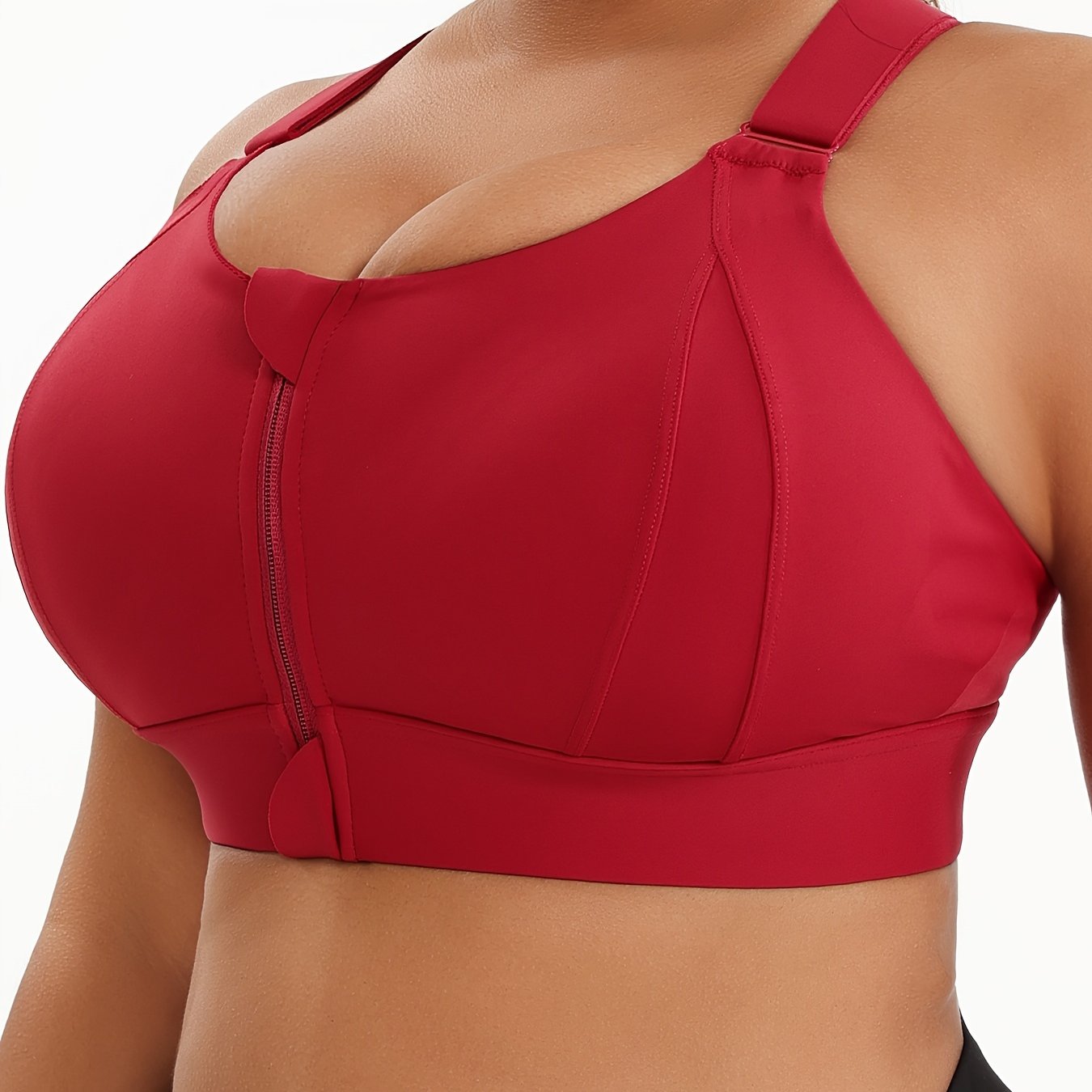 A woman wearing a red plus size sports bras with criss-cross back design sold by 100 Spartans