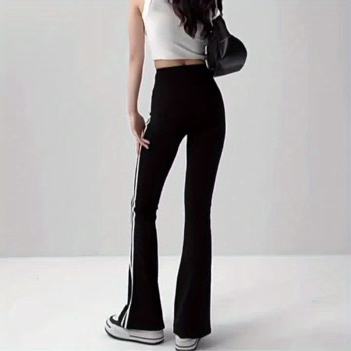 The back view of a woman wearing a women's black and white striped leggings sold by 100 Spartans