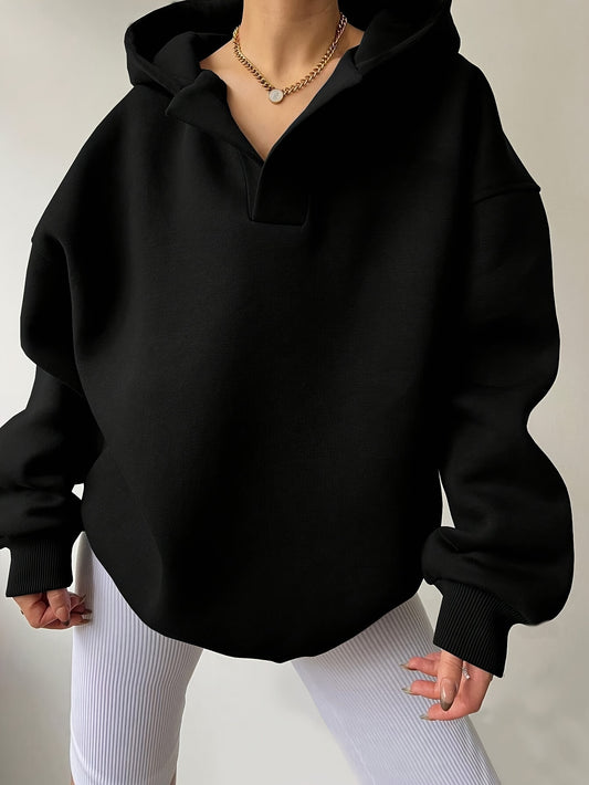The front view of a woman wearing a black winter hoodie for women sold by 100 Spartans