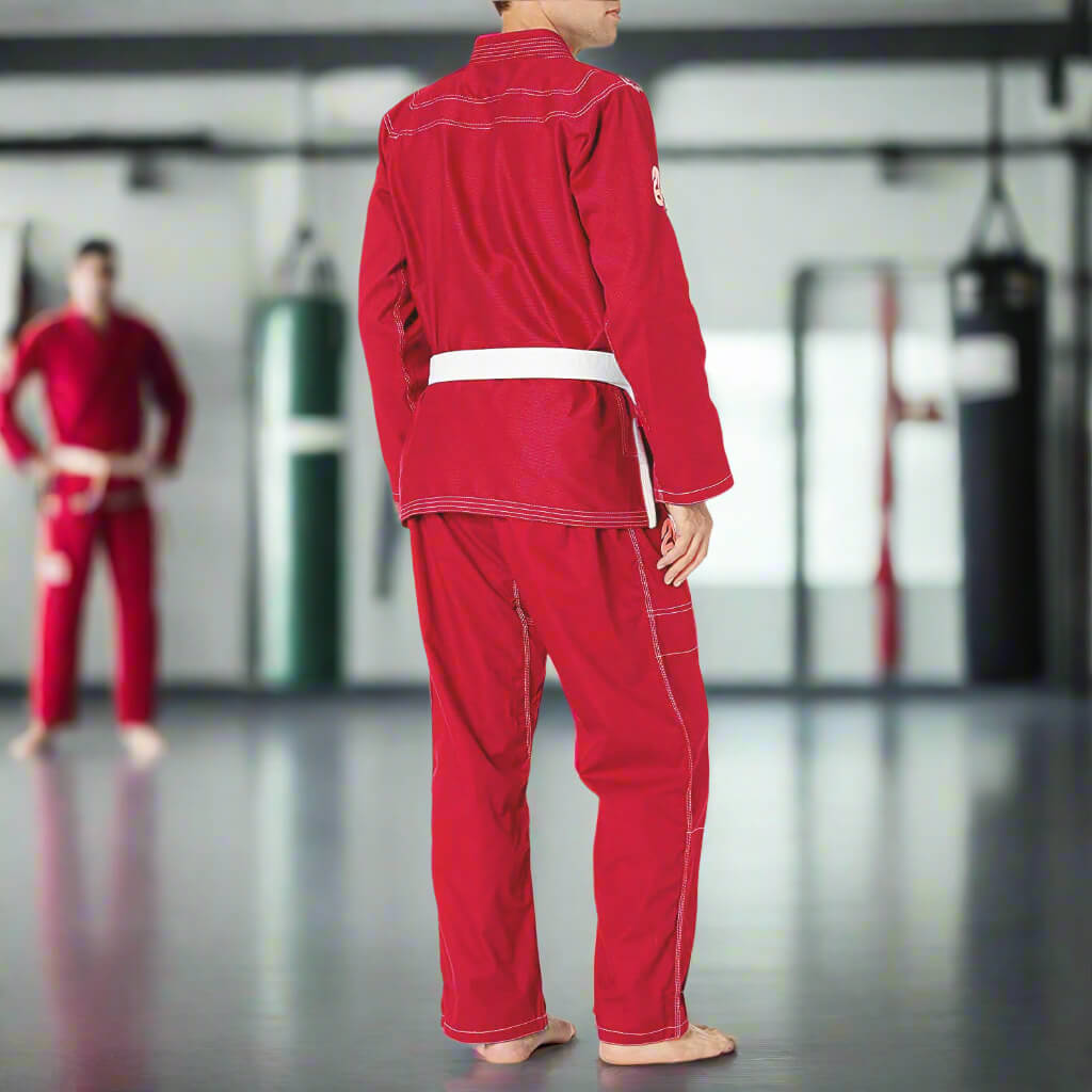 Person wearing a red martial arts uniform in a training room.