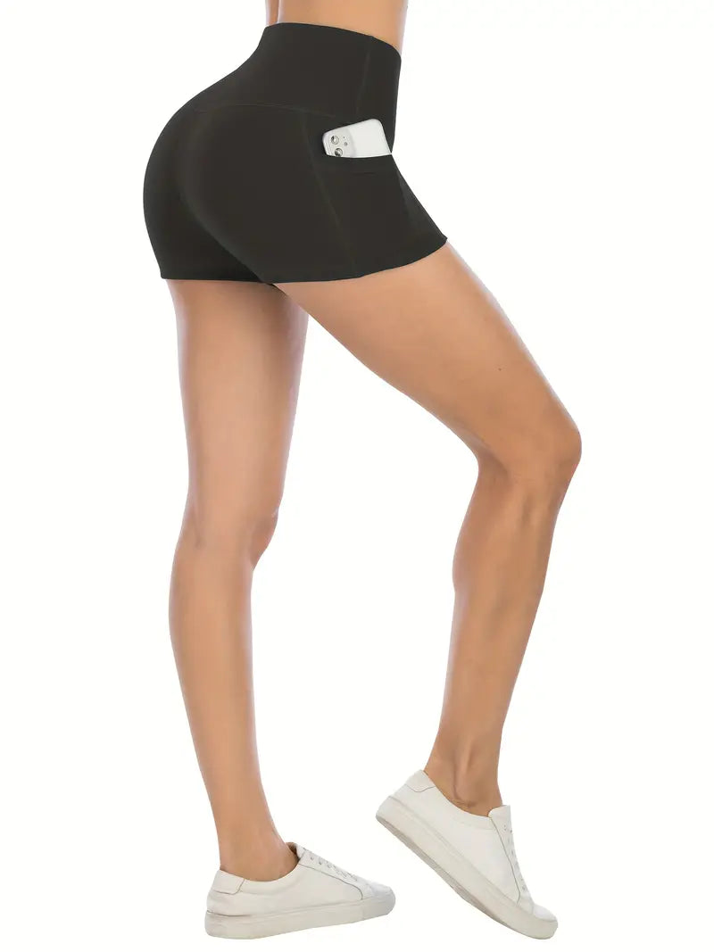 Black athletic biker shorts with pockets worn by a person on a white background