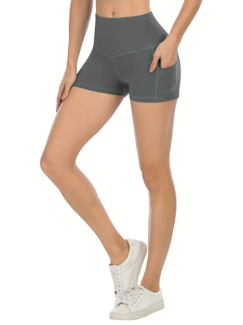 Person wearing gray biker shorts with pockets on a white background