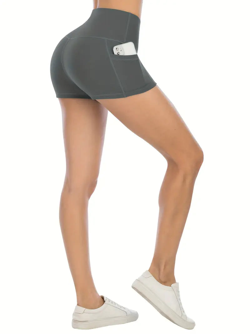 Gray athletic biker shorts with pockets worn by a person on a white background