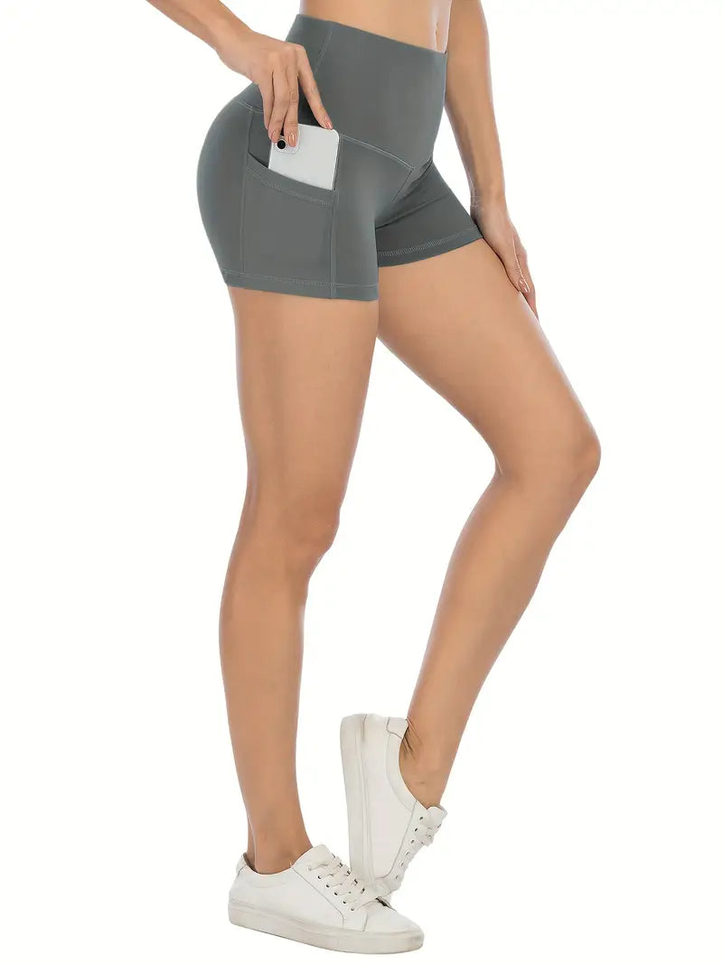 Person wearing gray biker shorts with pockets on a white background