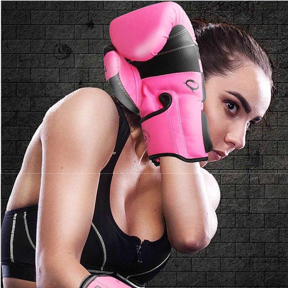 A woman blocking her face with a pink PU boxing gloves sold by 100 Spartans