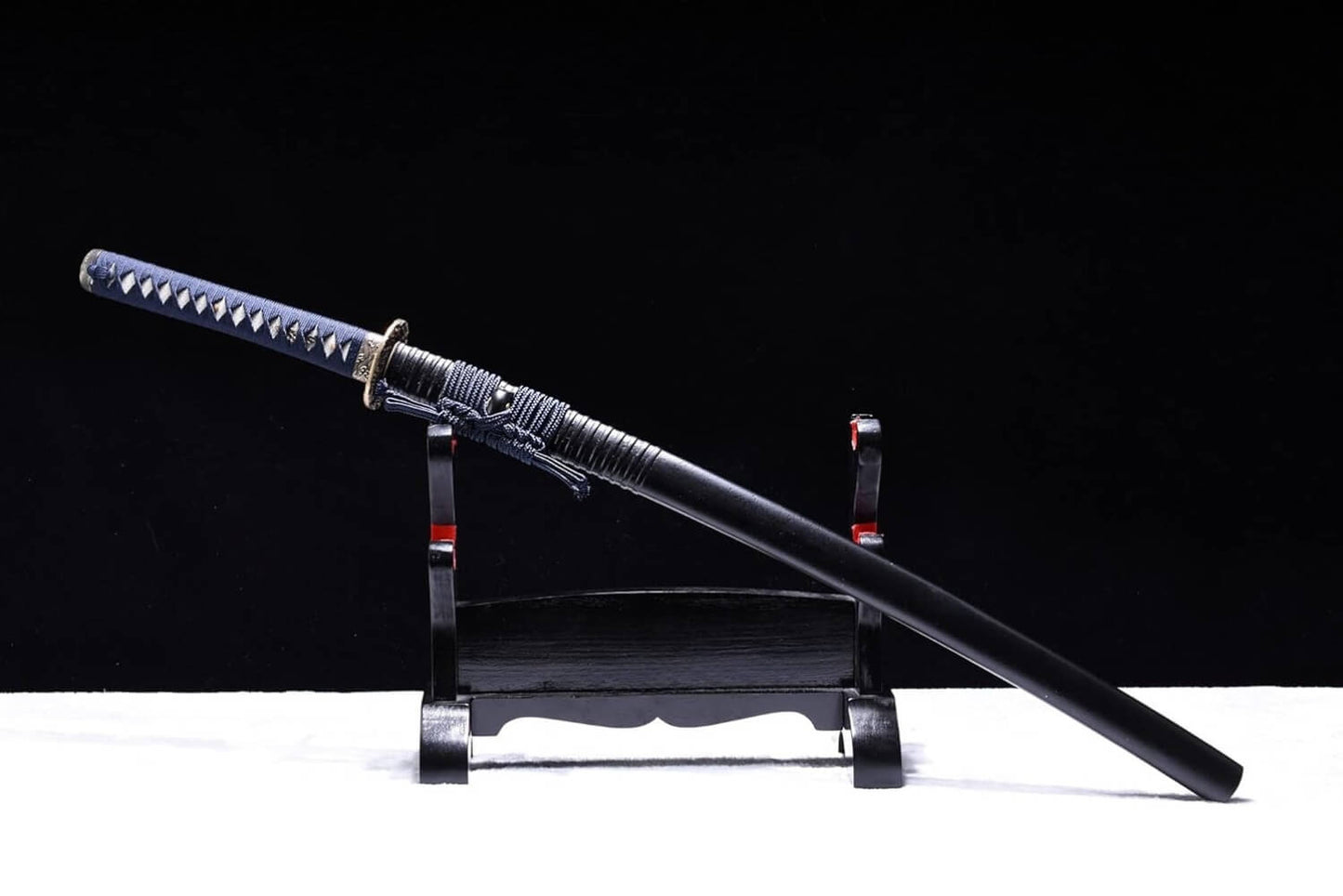 Katana training sword on a stand against a black background