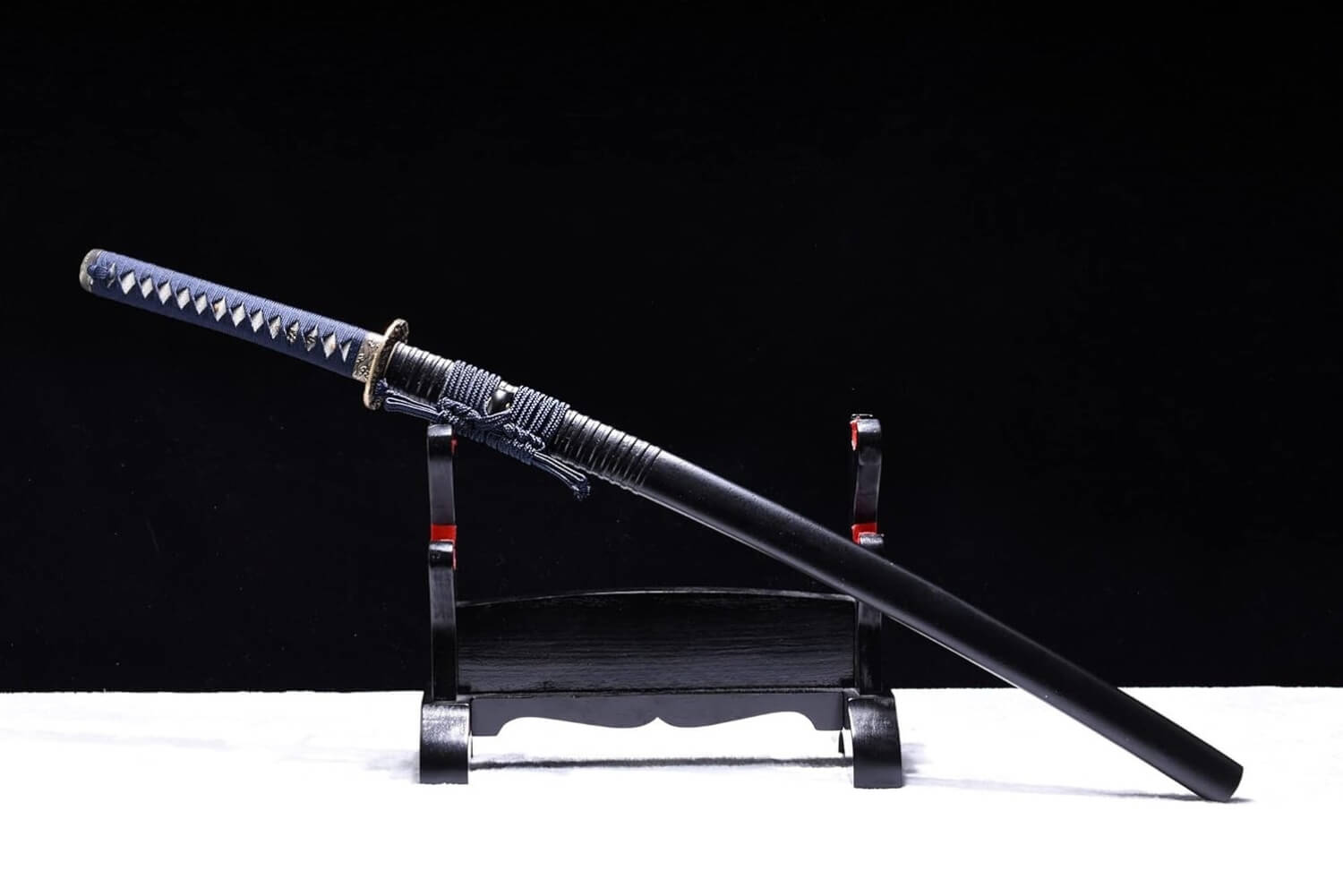 Katana training sword on a stand against a black background