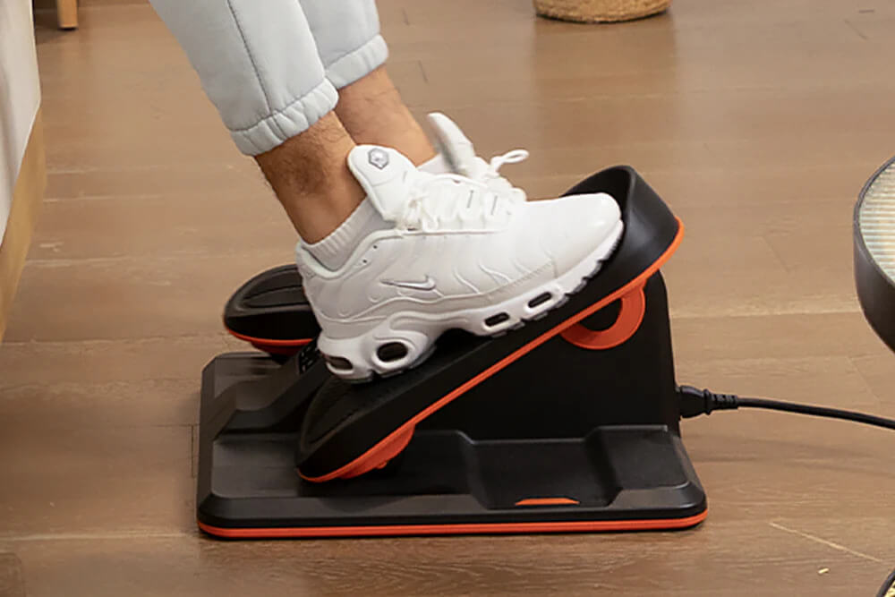 Feet exercising on an under desk electric elliptical machine sold by 100 Spartans