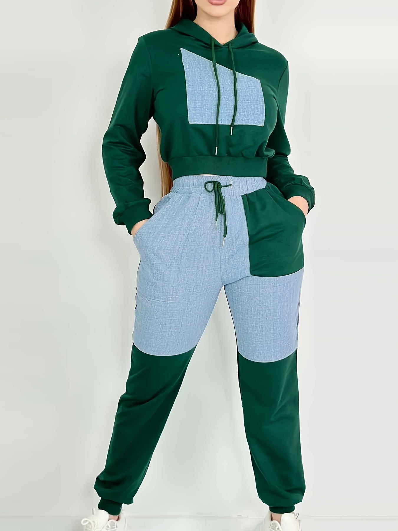 Green and blue matching women's luxury tracksuit set worn by a person on a white background