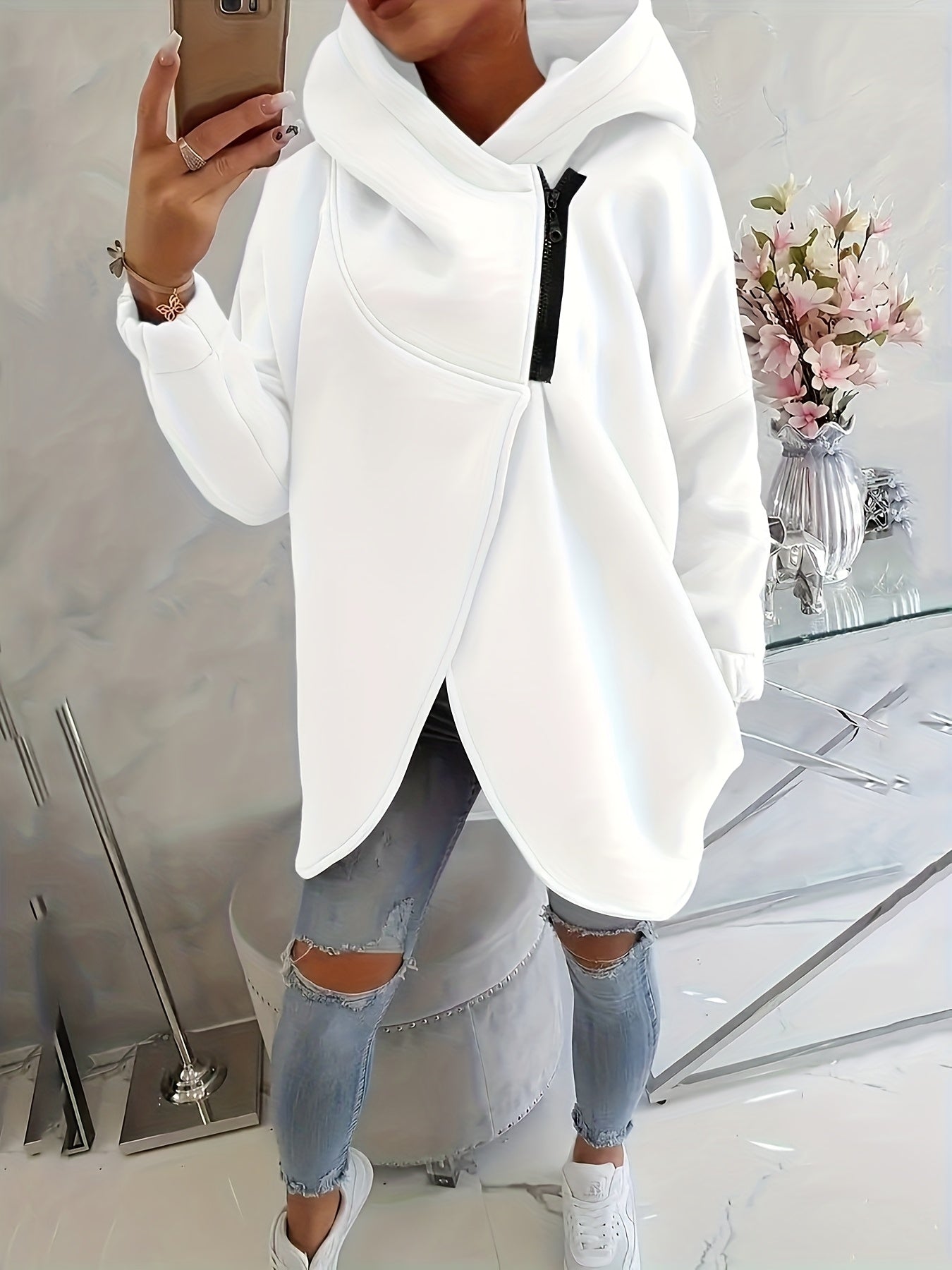 A person wearing a white women’s oversized zip-up hoodie
