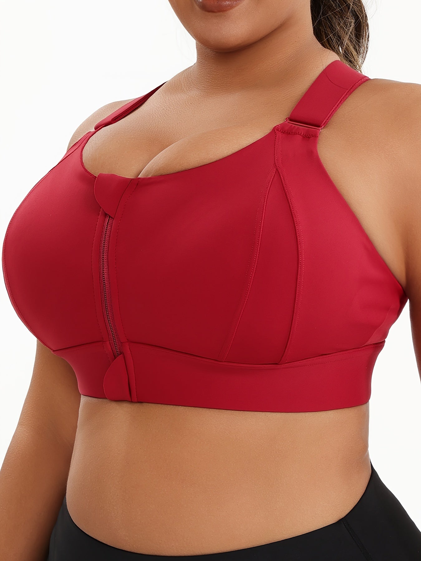 A woman wearing a red plus size sports bras with criss-cross back design sold by 100 Spartans