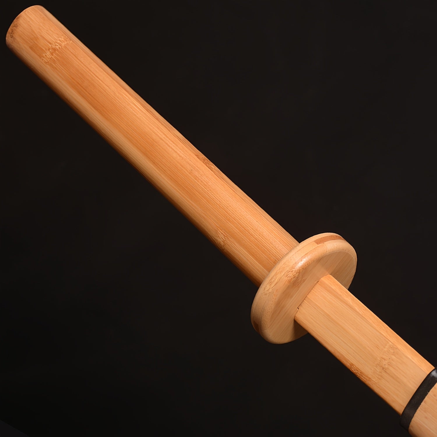Wooden training sword handle on a black background