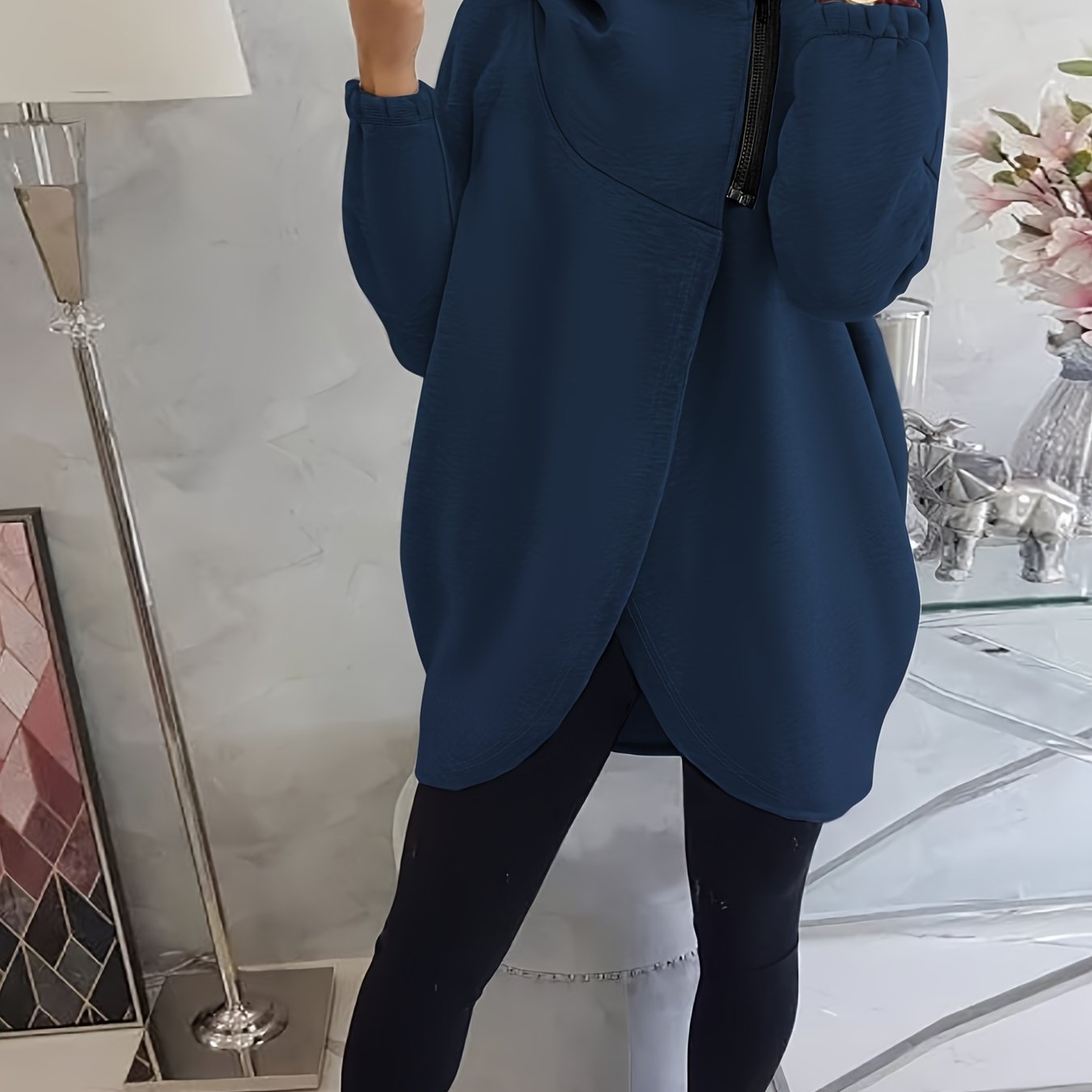 A person wearing a blue women’s oversized zip-up hoodie