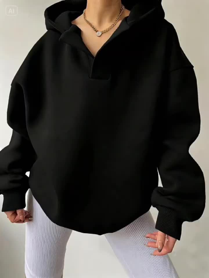 The front view of a woman wearing a black winter hoodie for women sold by 100 Spartans