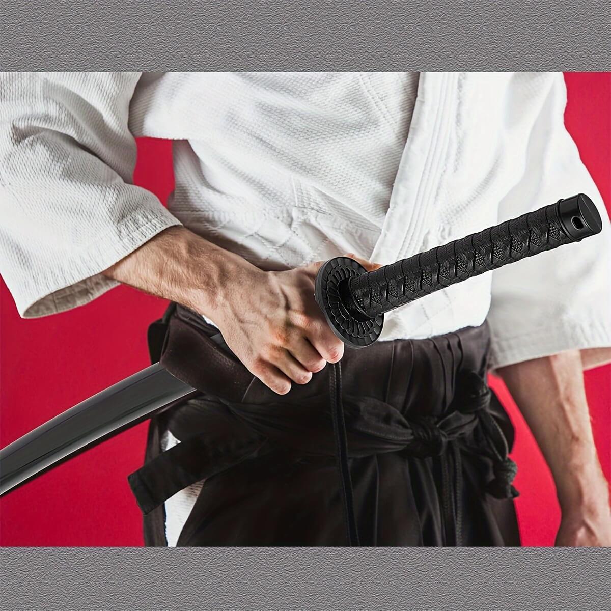 Person in a white martial arts uniform holding a black training sword against a red background