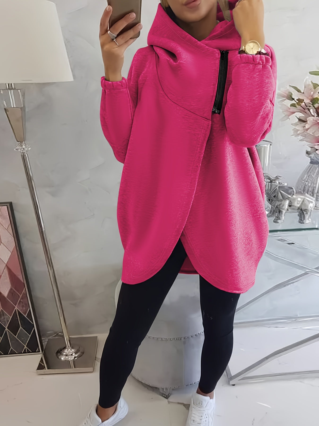 A person wearing a pink women’s oversized zip-up hoodie