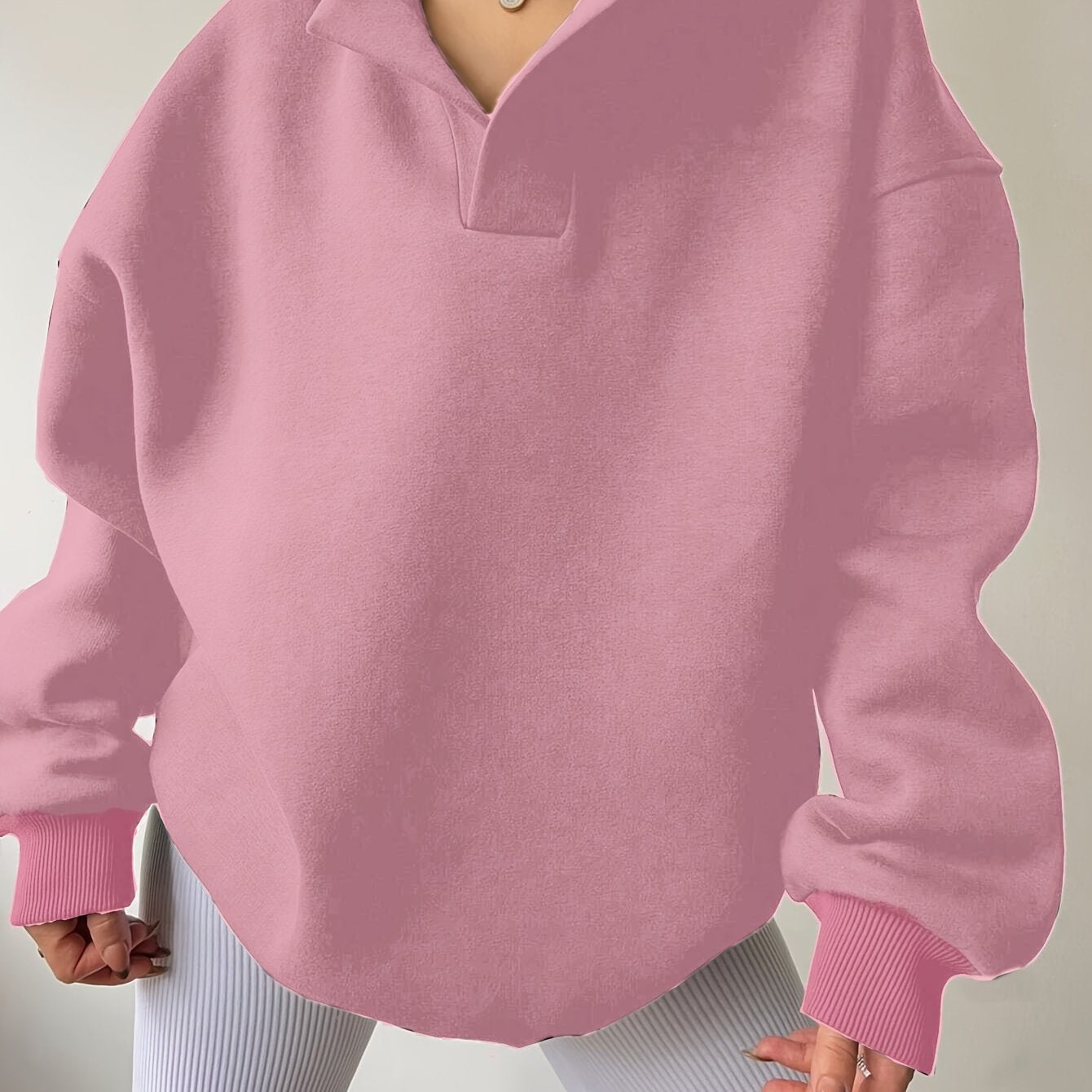 The front view of a woman wearing a pink winter hoodie for women sold by 100 Spartans