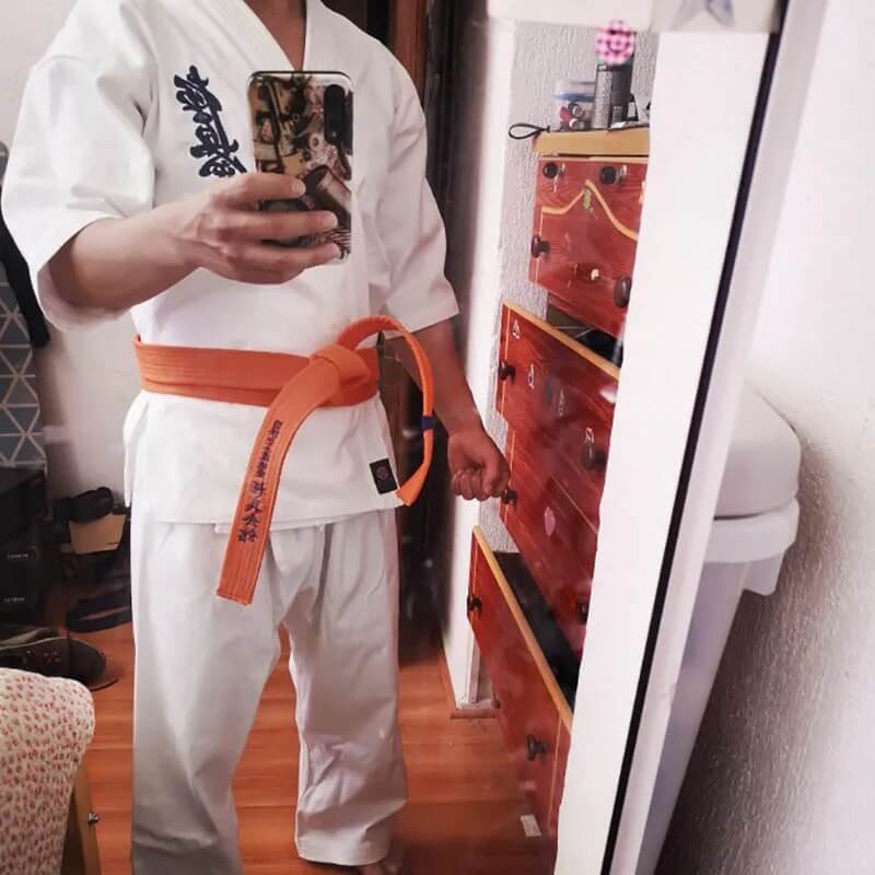 A man wearing a 12oz Kyokushin Karate Uniform sold by 100 Spartans