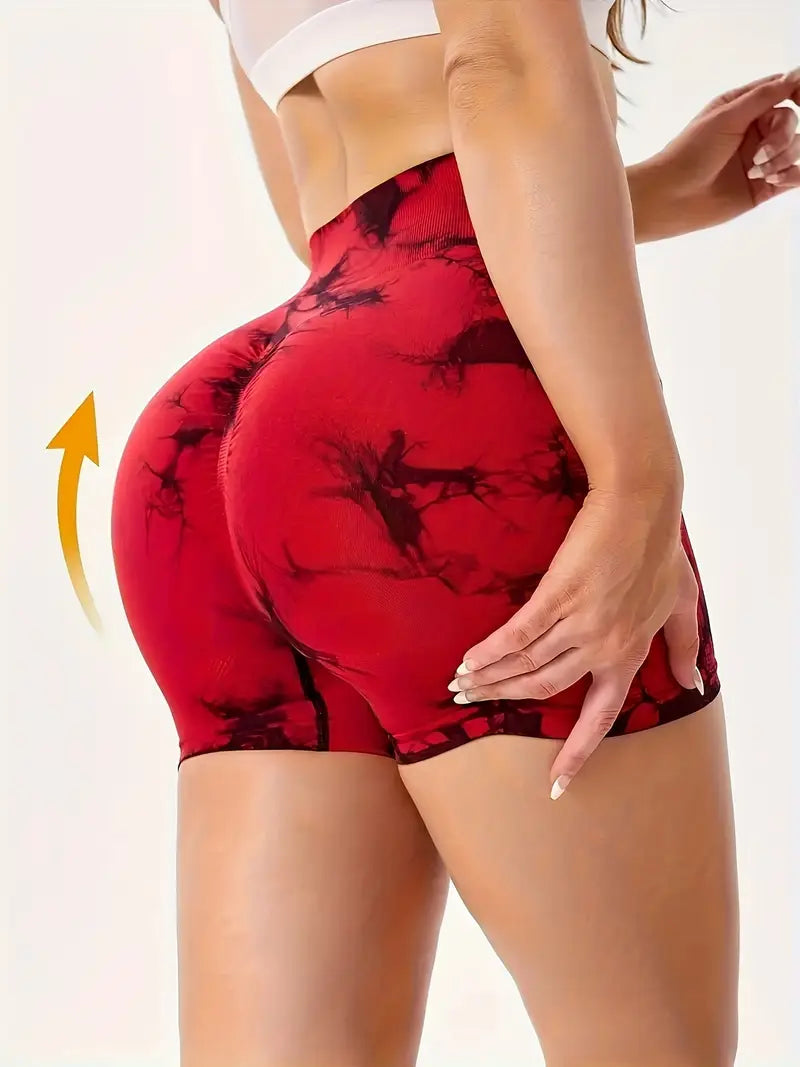Red and black patterned women's yoga shorts worn by a person on a plain background