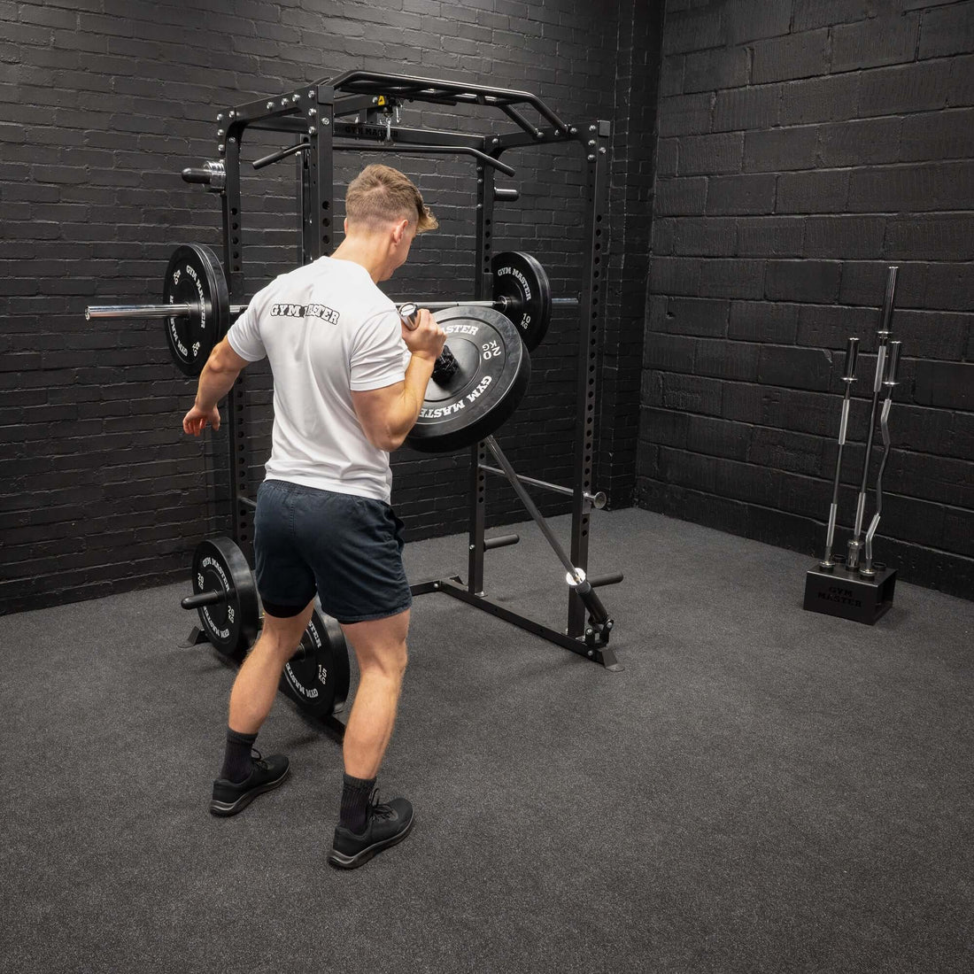 A man working out with a landmine attachment attached to a smith machine