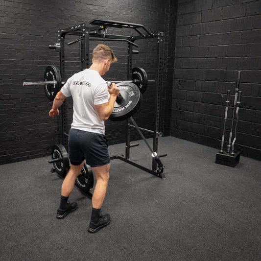 A man working out with a landmine attachment attached to a smith machine