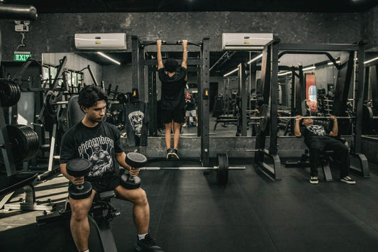 People working out in the gym wiht dumbbells and smith machines
