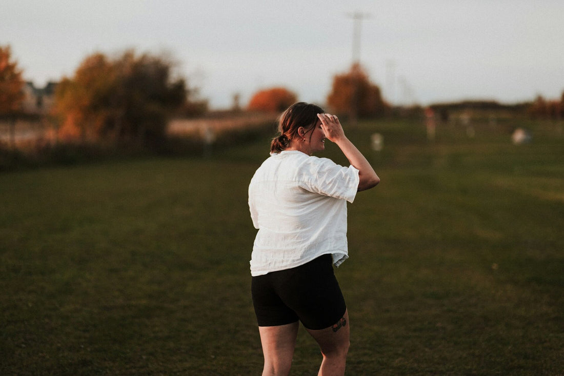 A woman in a field wearing biker shorts 