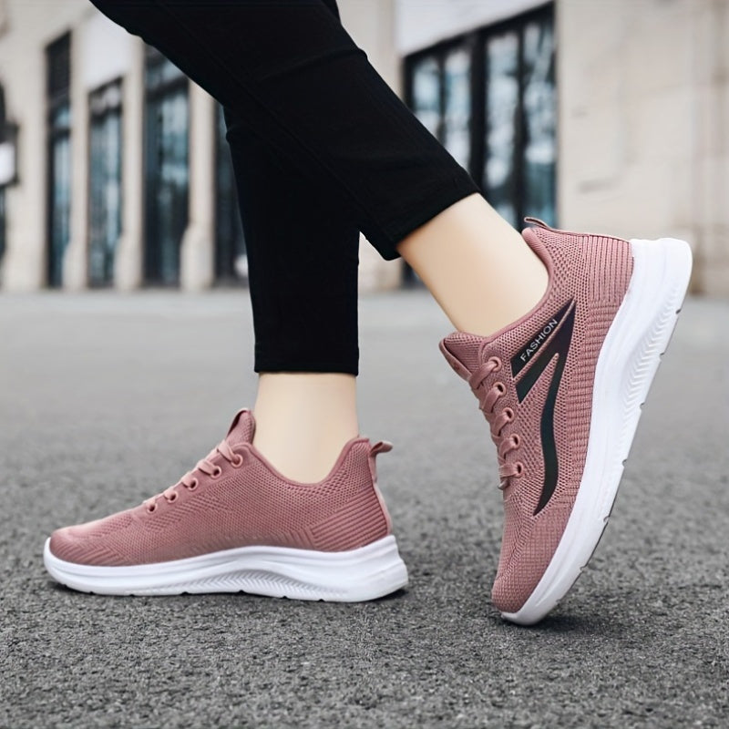 Pink running shoes with white soles worn by a person on a pavement.