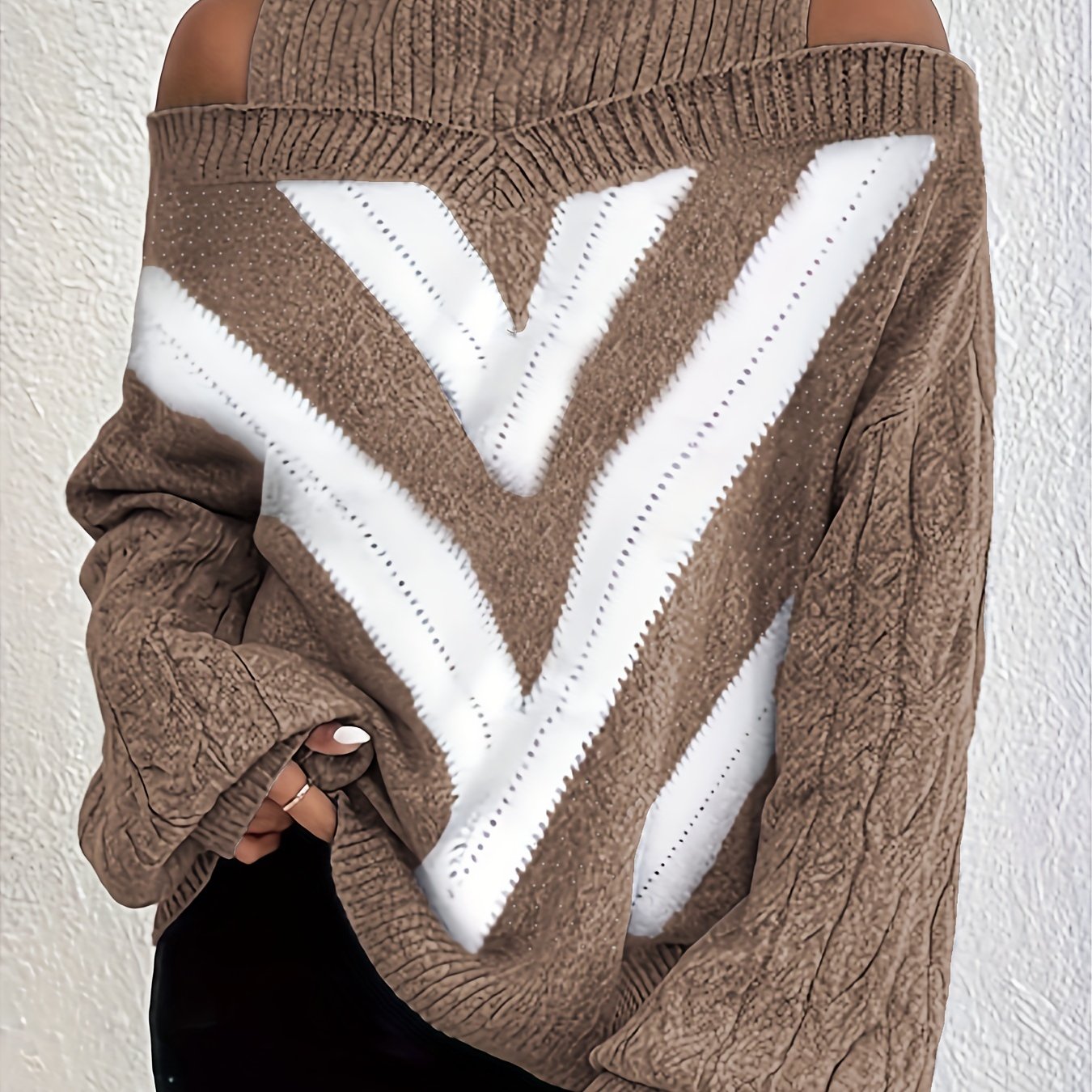 Brown off the shoulder sweater with white V-shaped pattern on a plain background