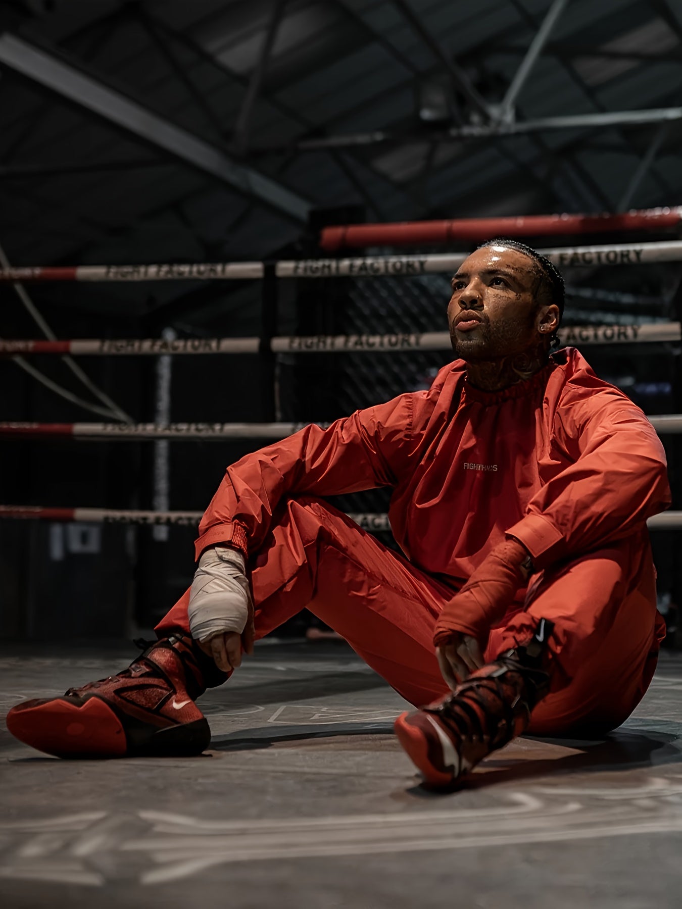 Person in red mens sauna sweat suit sitting on a boxing ring
