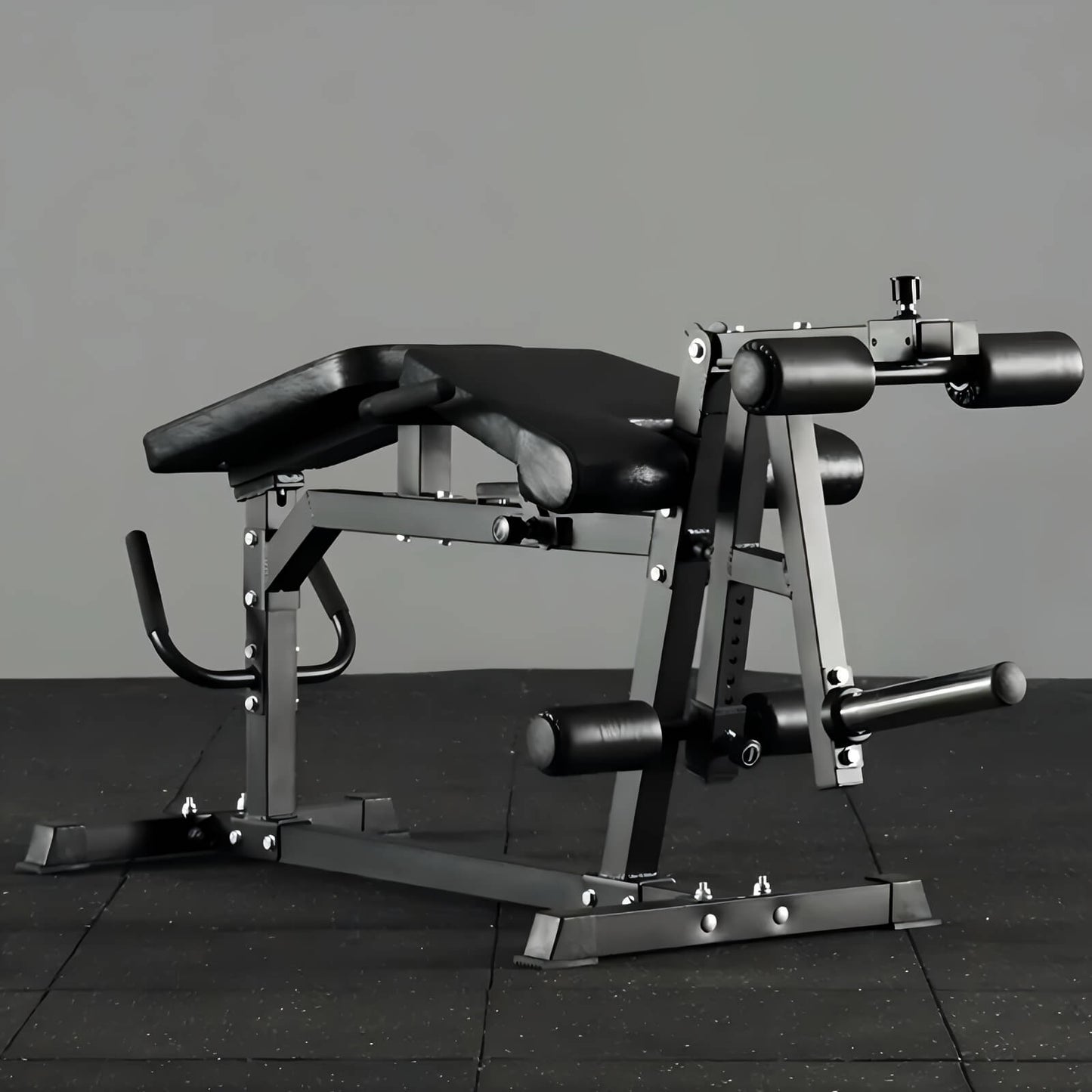 Black leg exercise machine on a dark tiled floor with a gray background
