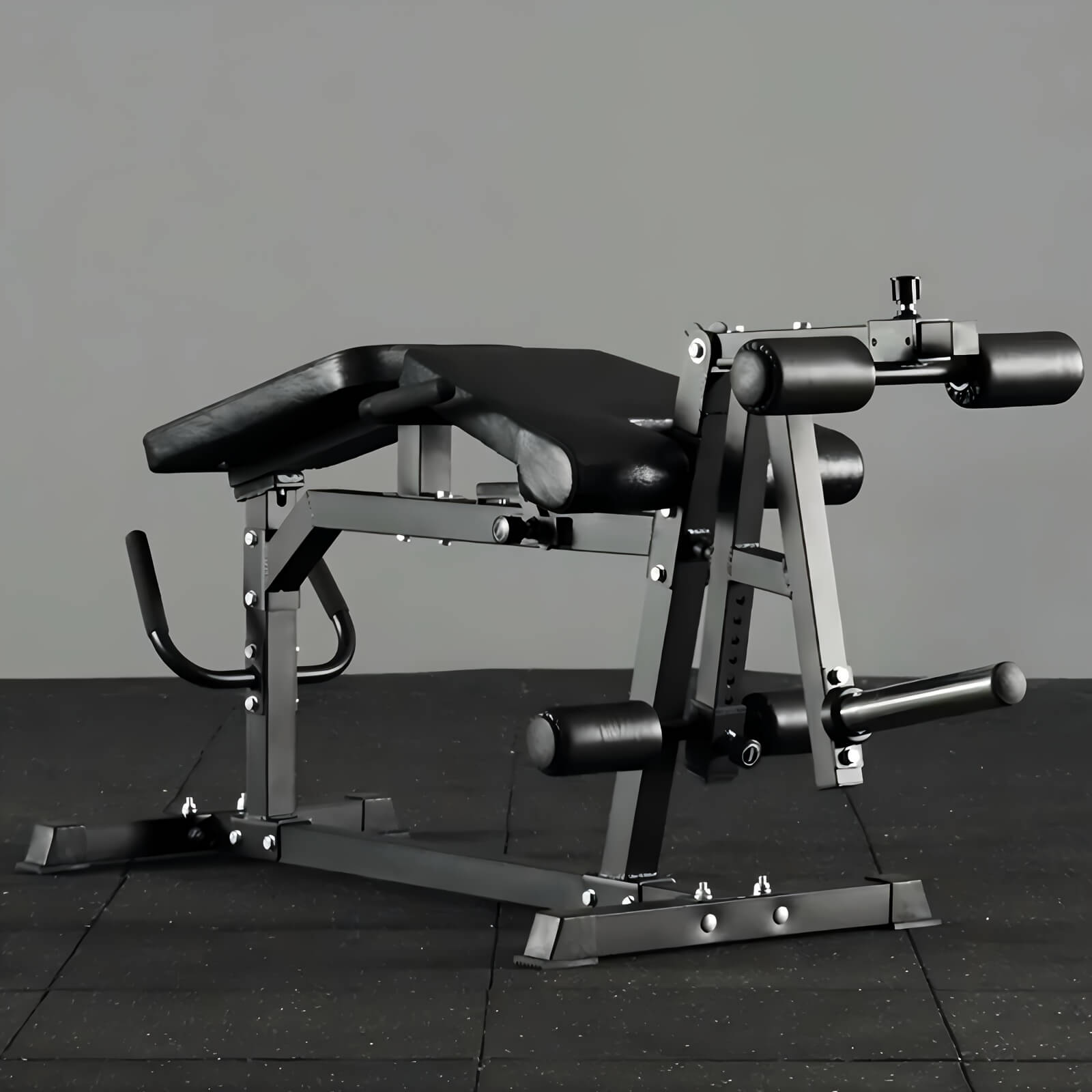 Black leg exercise machine on a dark tiled floor with a gray background
